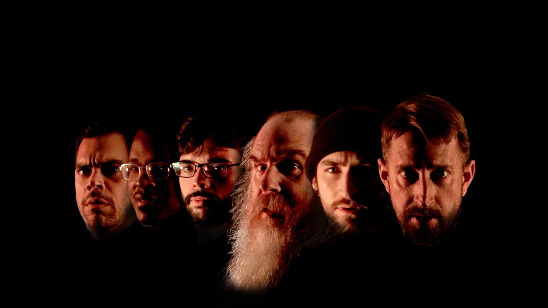 Six men's faces in a lineup against a black background, showing various expressions and styles.