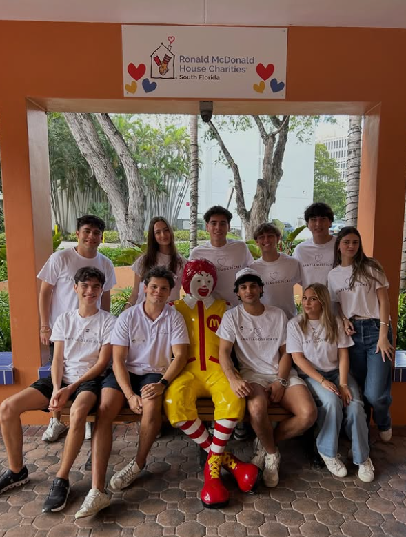 Group of teenagers posing with Ronald McDonald statue at Ronald McDonald House Charities in South Florida.