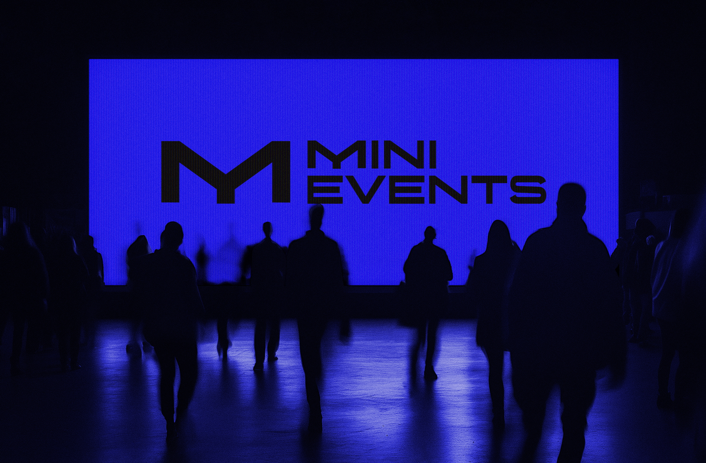 A group of silhouettes of people standing in front of a large illuminated screen displaying the text 'Mini Events' in black against a blue background.