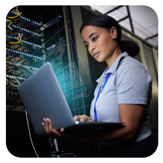 Female technician working on a laptop in a server room with networking equipment and digital data visualizations.