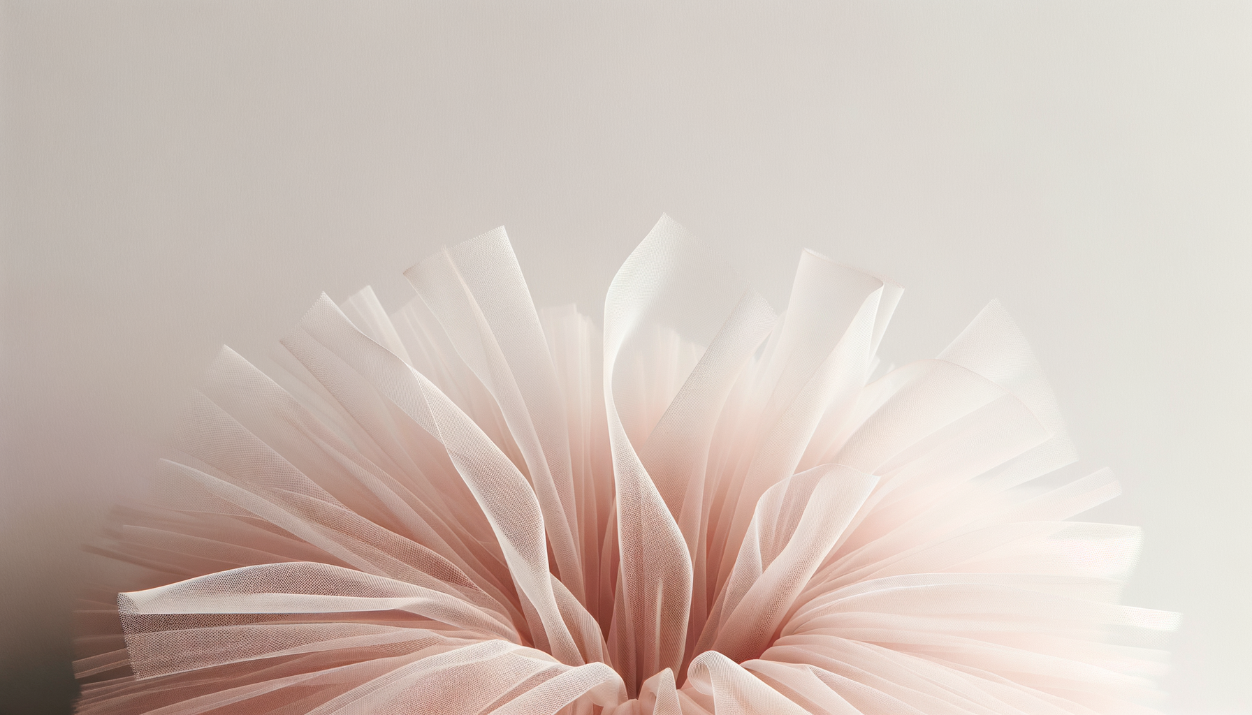 Close-up of a delicate, pale pink tulle fabric arranged in a circular fashion with a soft, neutral background.