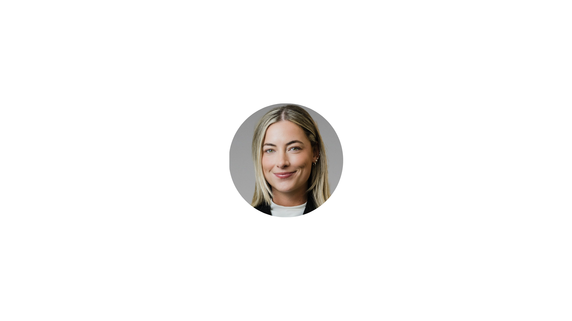 Headshot of a smiling woman with blonde hair against a neutral gray background.