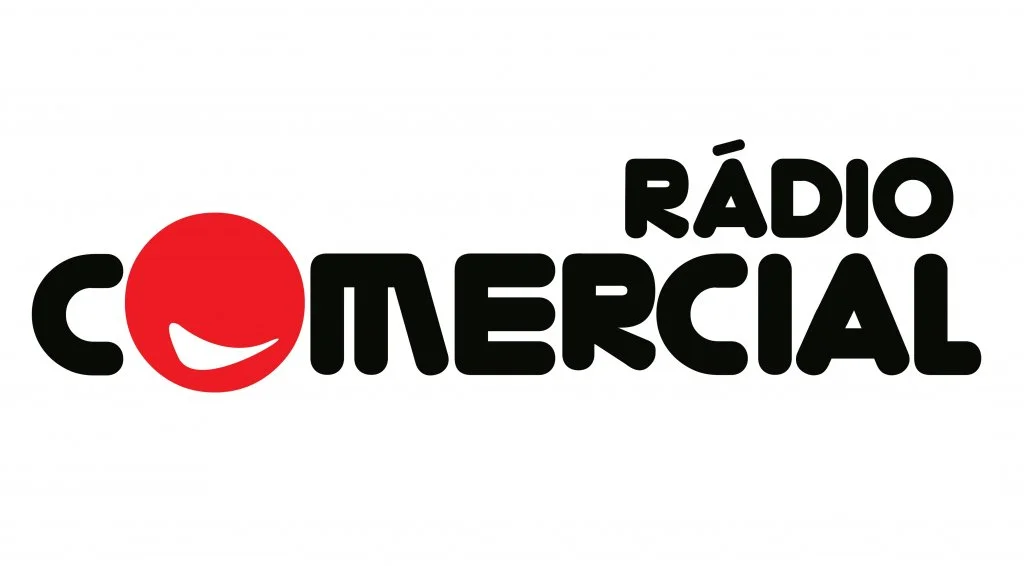 Logo of Rádio Comercial with a red smiling face replacing the letter 'O' in 'COMERCIAL'