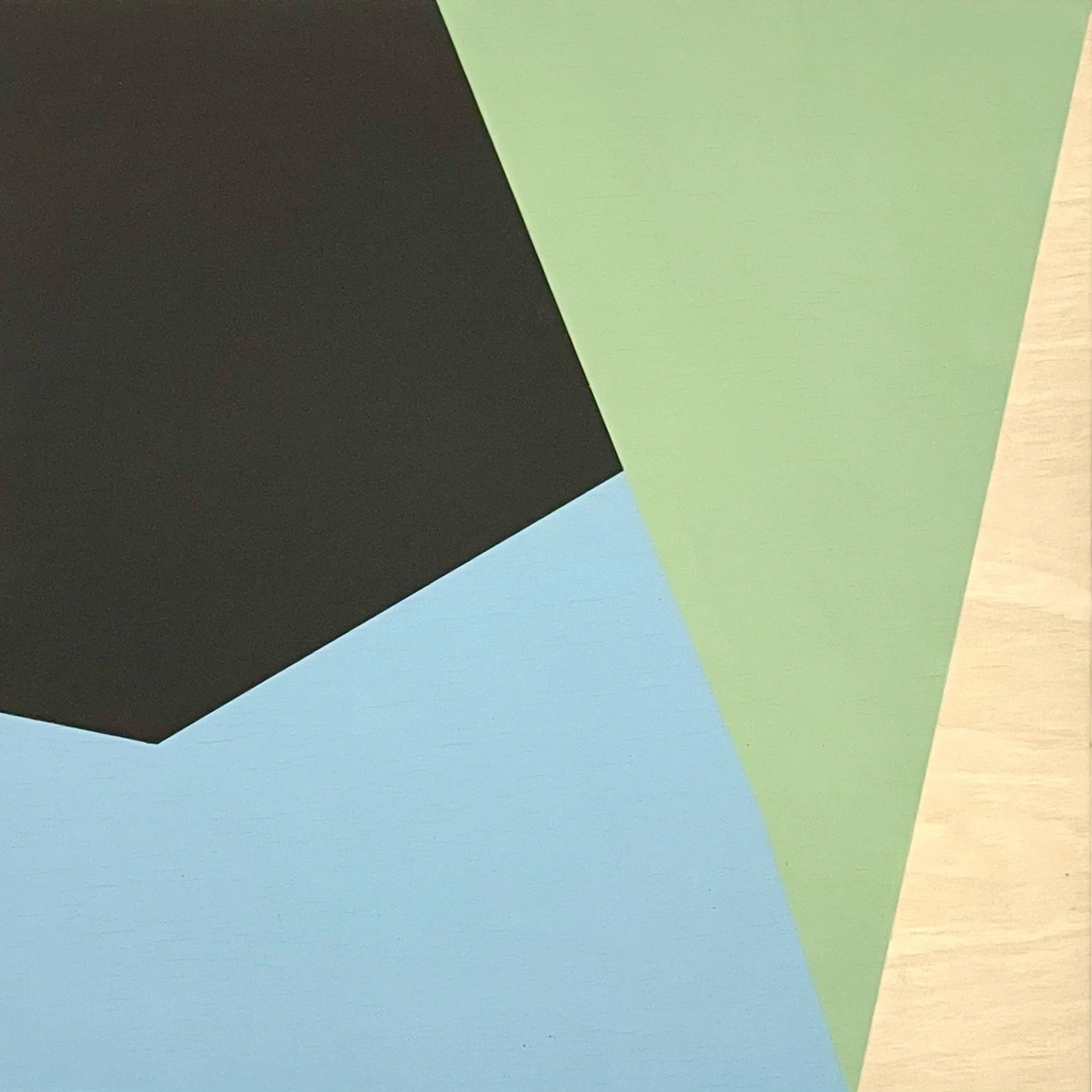 Close-up of overlapping geometric shapes in black, green, blue, and beige colors.