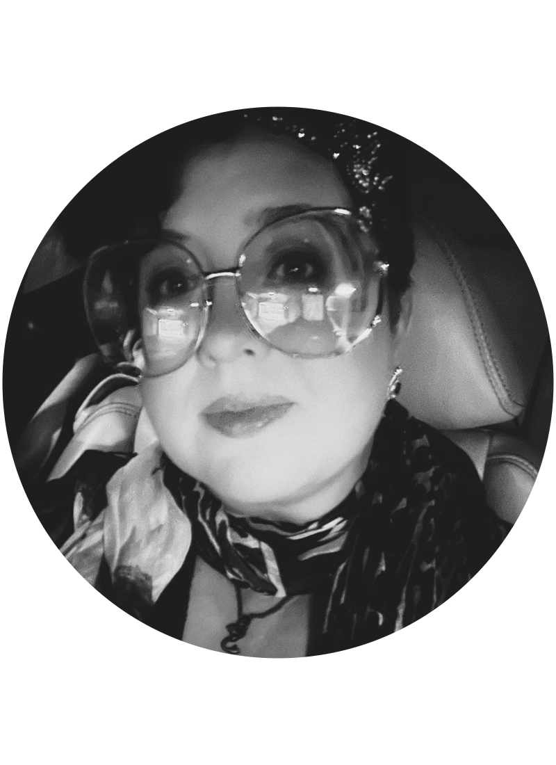 Professional Portrait of Founder and Executive Creative Director Marisa Erven with glasses, a decorative scarf, and headband on, looking up towards the camera.