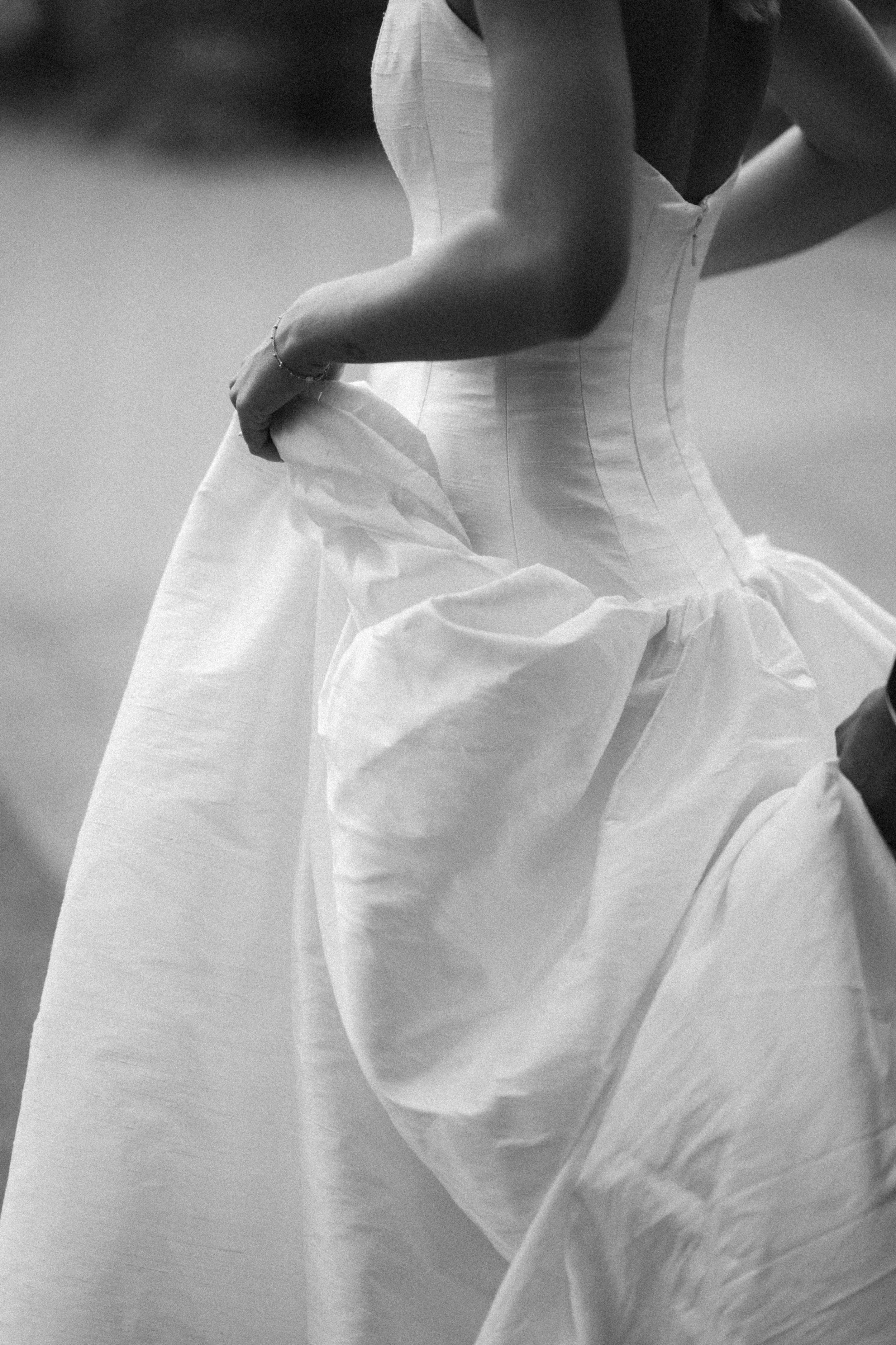 A woman in a wedding dress holding the skirt.