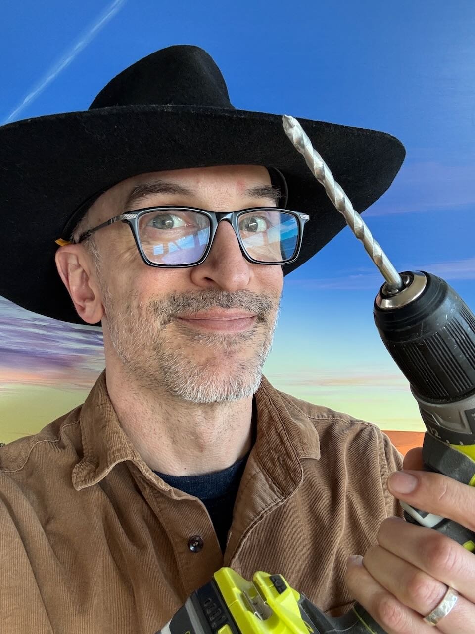 Kevin, the Holland Cowboy expat handyman, wearing a cowboy hat and holding a drill