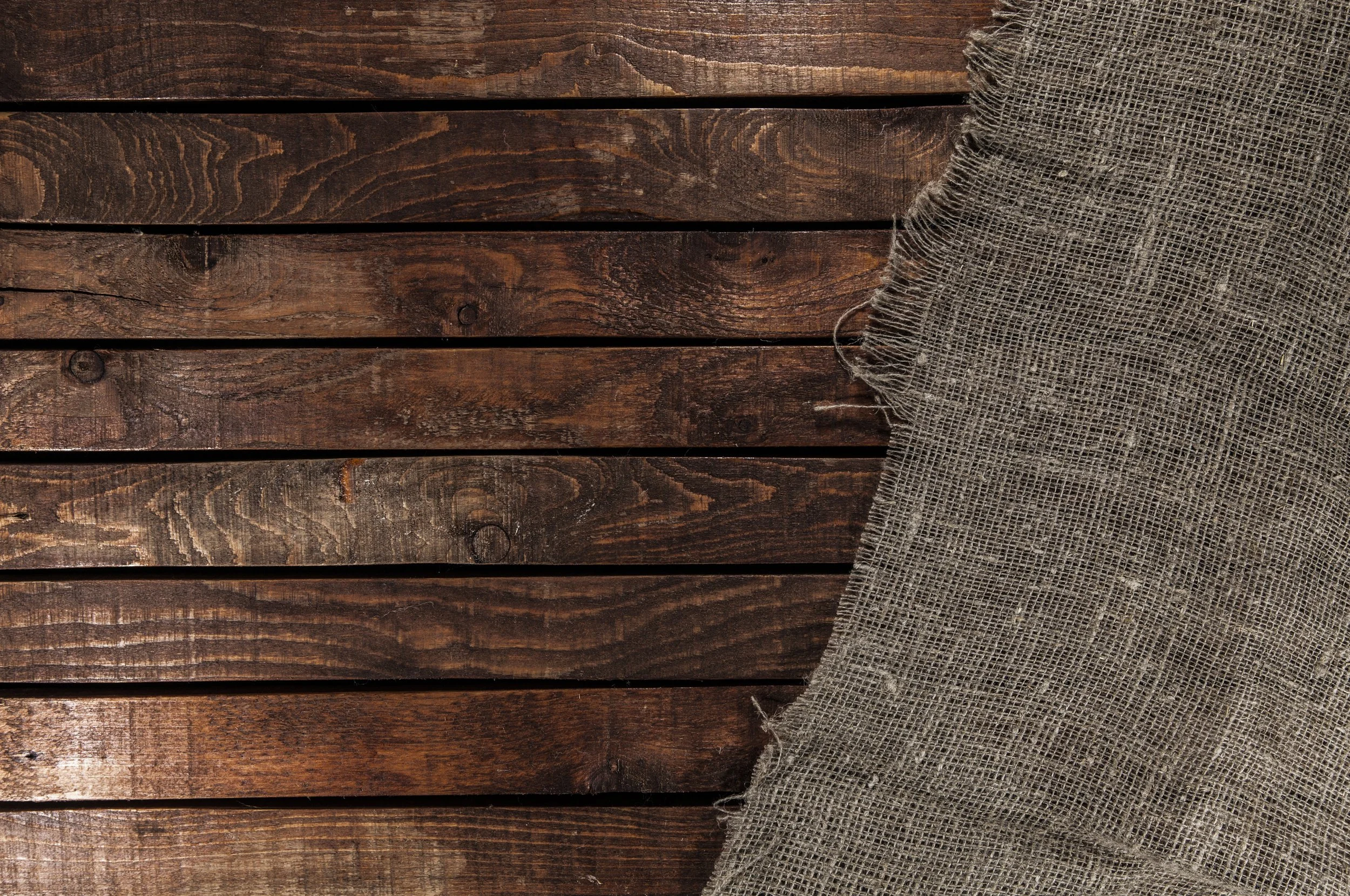 Wooden planks with a coarse burlap cloth partially covering the right side.