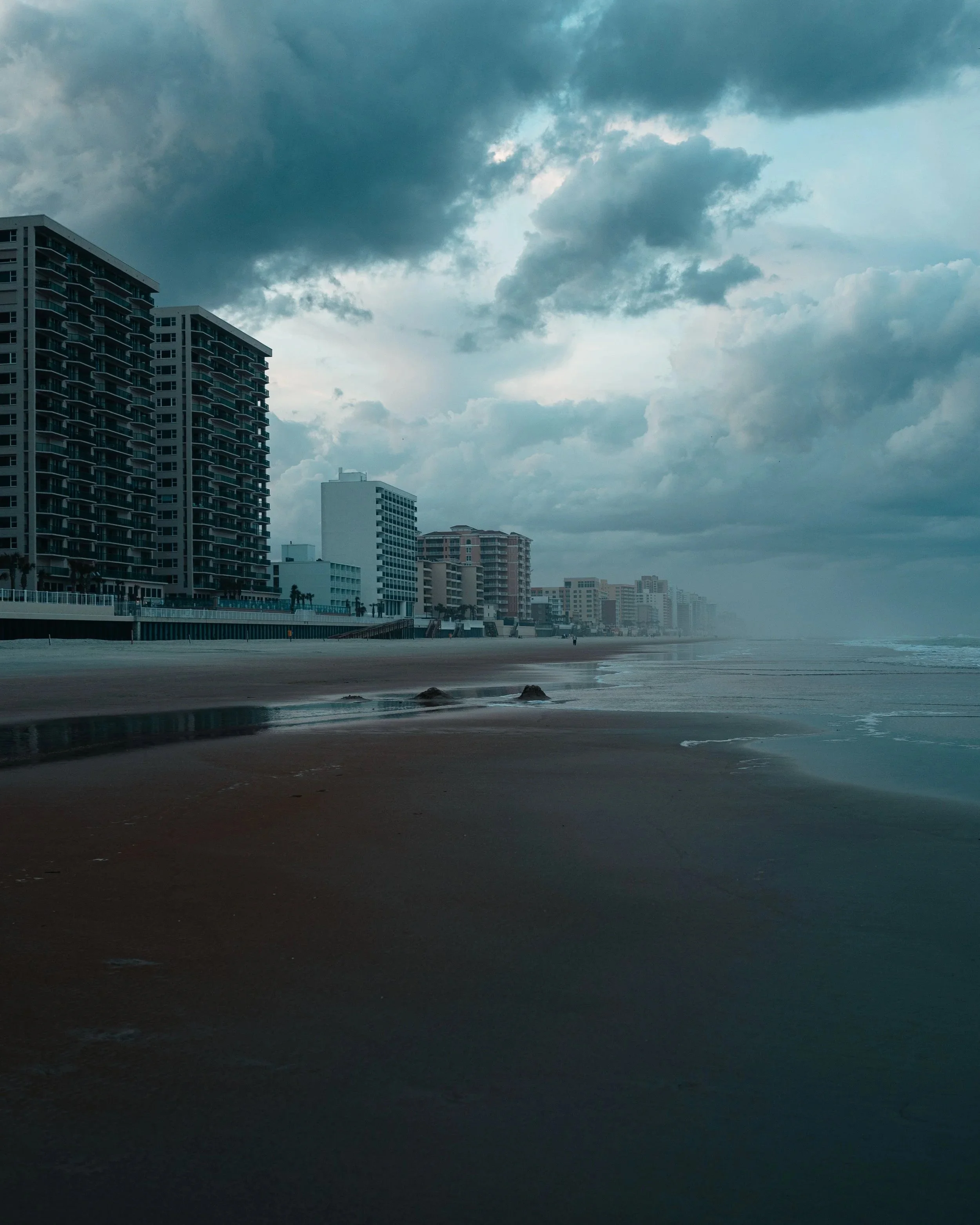 Overcast sky over a beach with buildings along the shoreline
