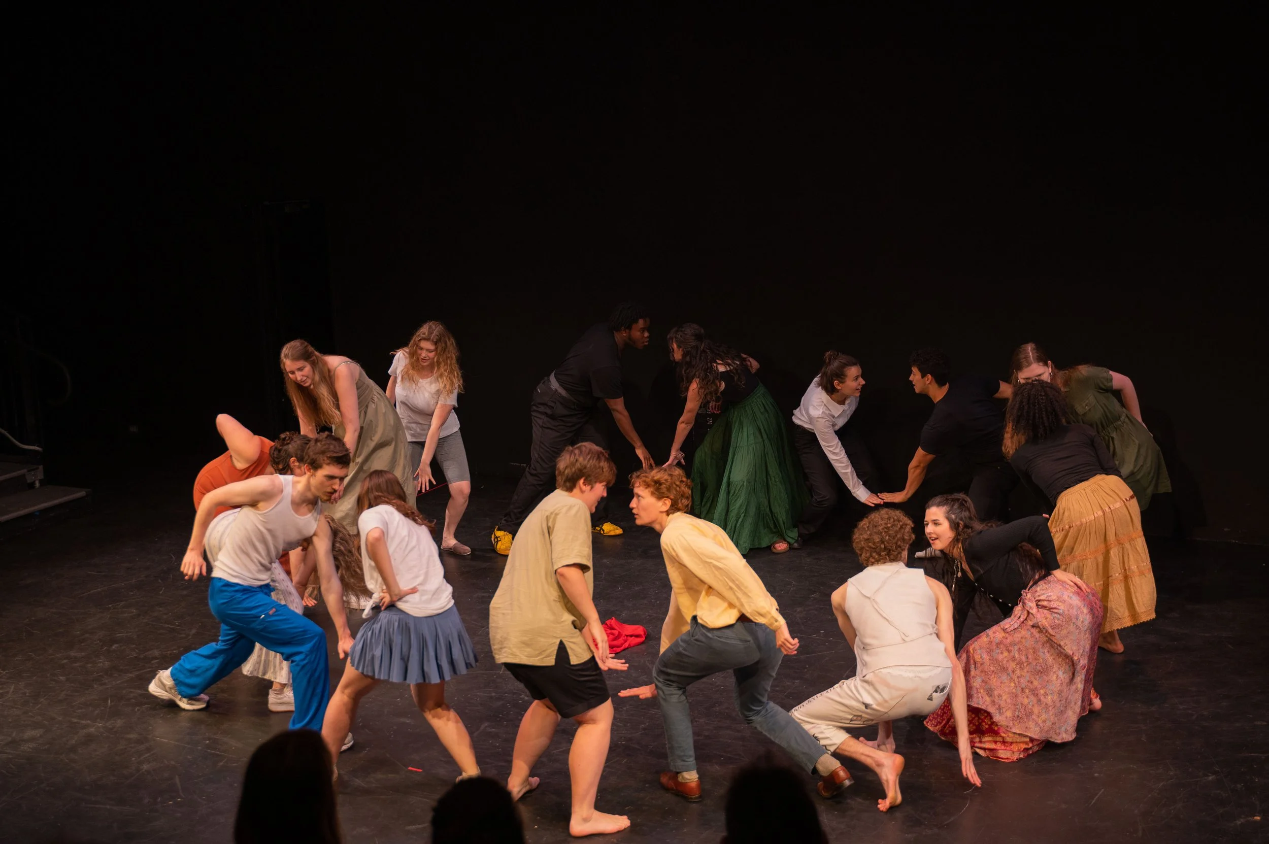 Group of diverse performers dancing and acting on stage.