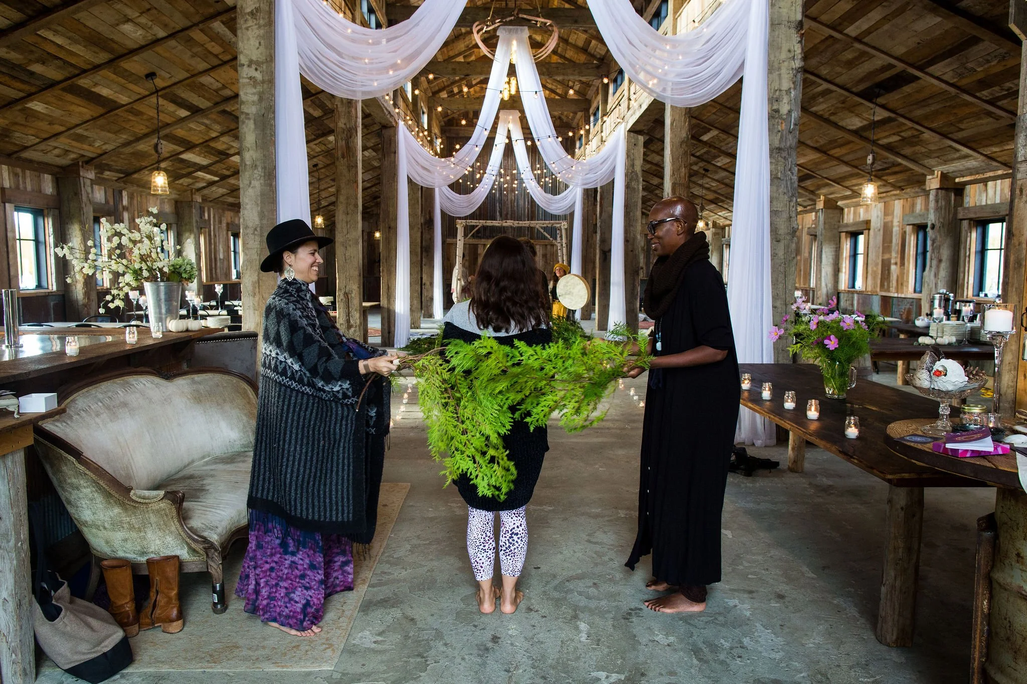 People walking into a softly lit indoor venue with draped fabric and ambient lighting, viewed from the entrance.