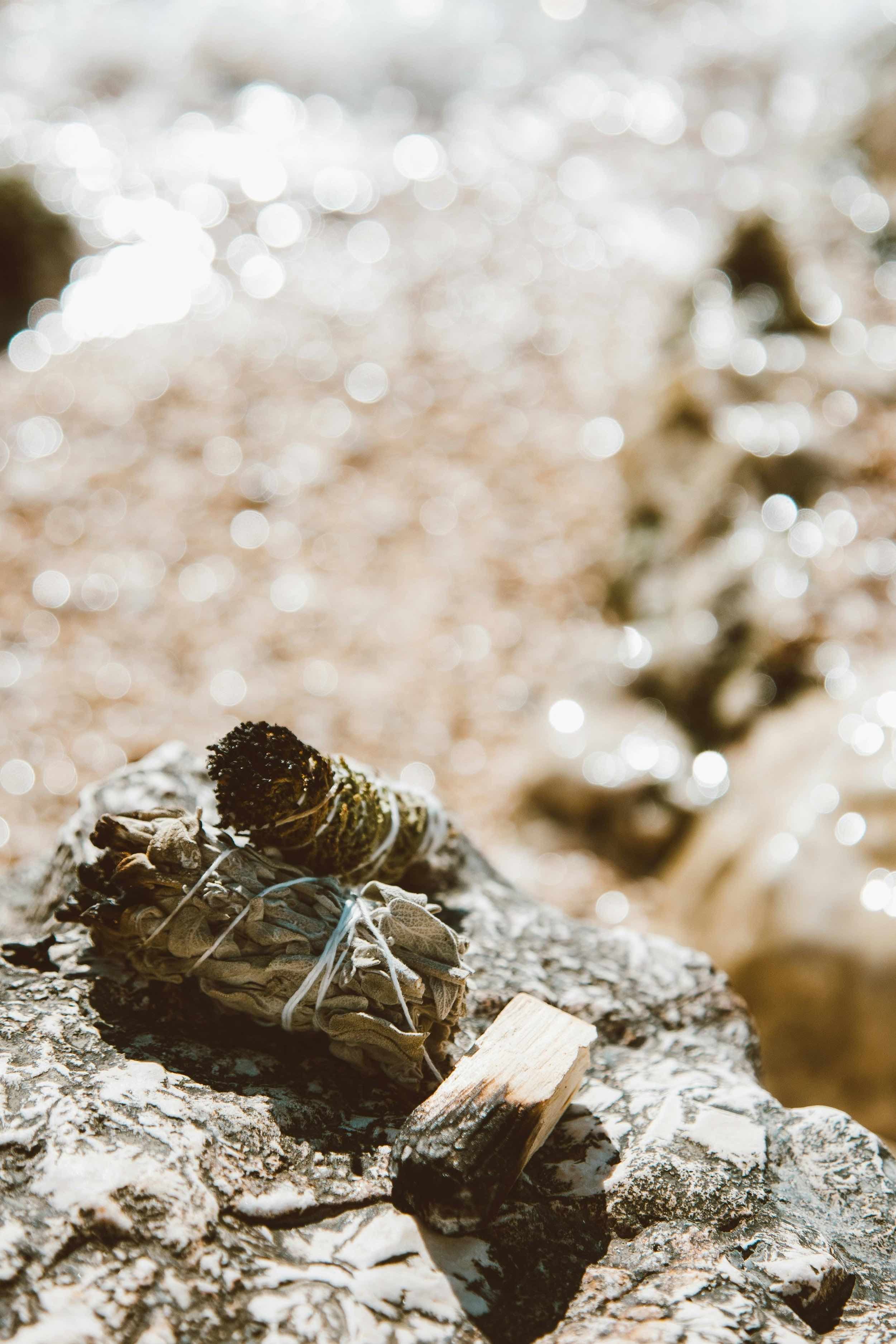 Close-up of several small crystals resting on sunlit sand with a soft, natural background.