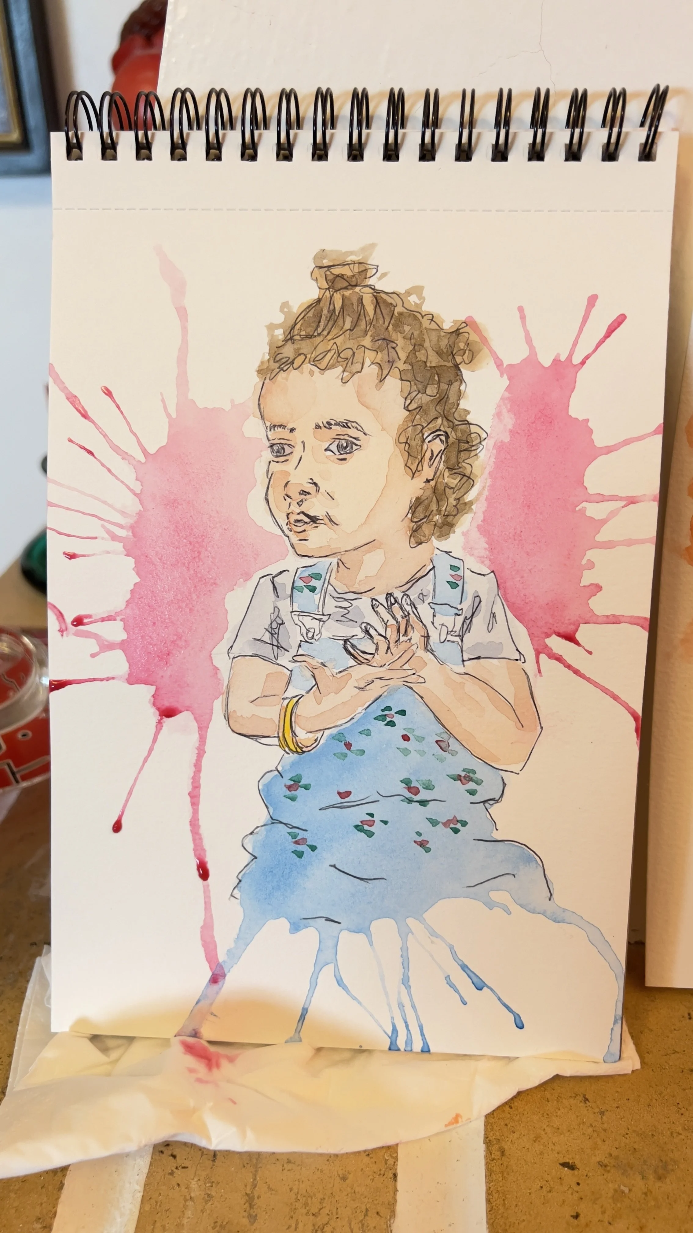 Pintura aquarela de uma criança com fundo de respingos coloridos.