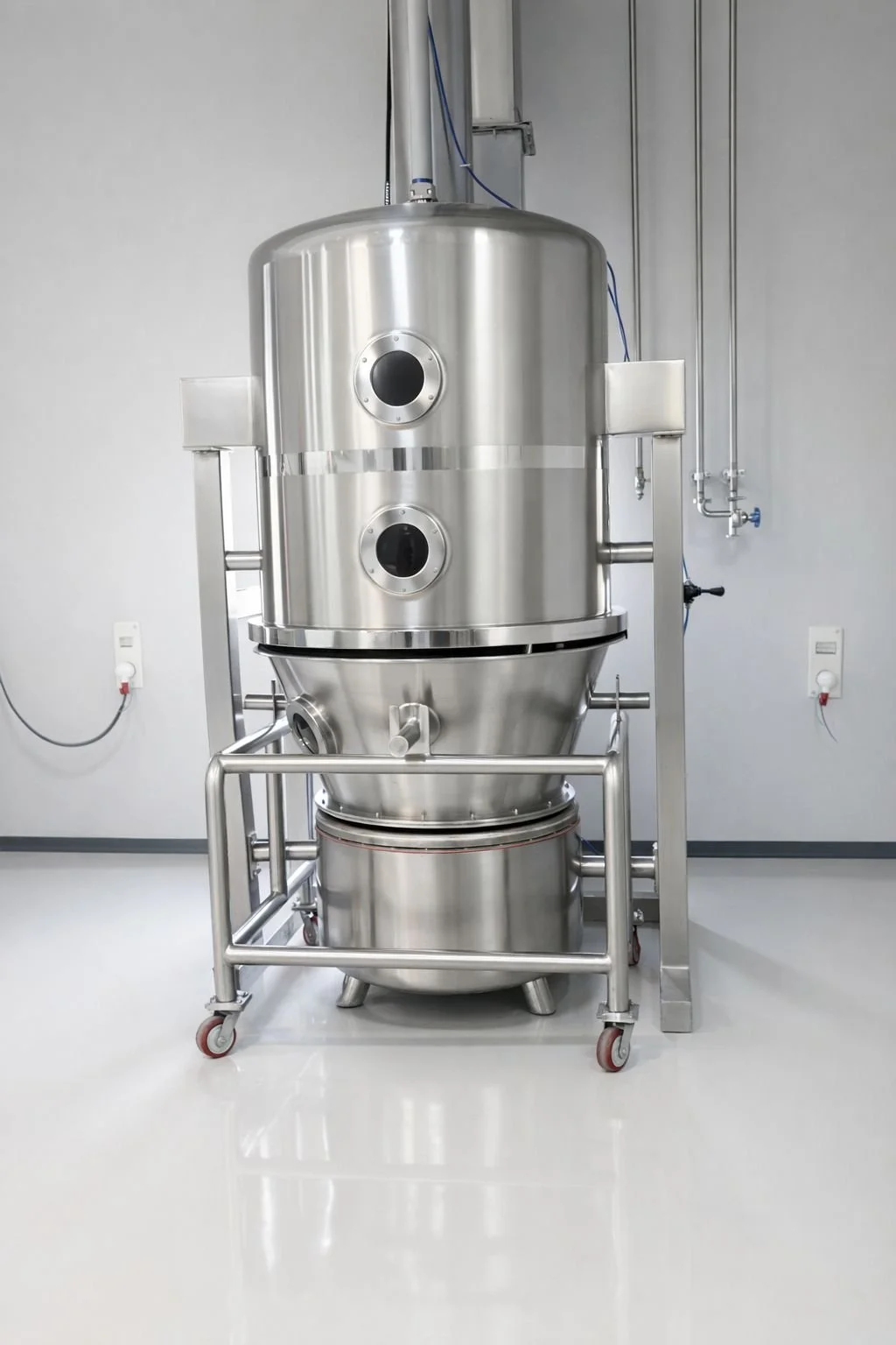 Large stainless steel industrial vacuum chamber or processing vessel in a clean, modern laboratory or manufacturing facility.
