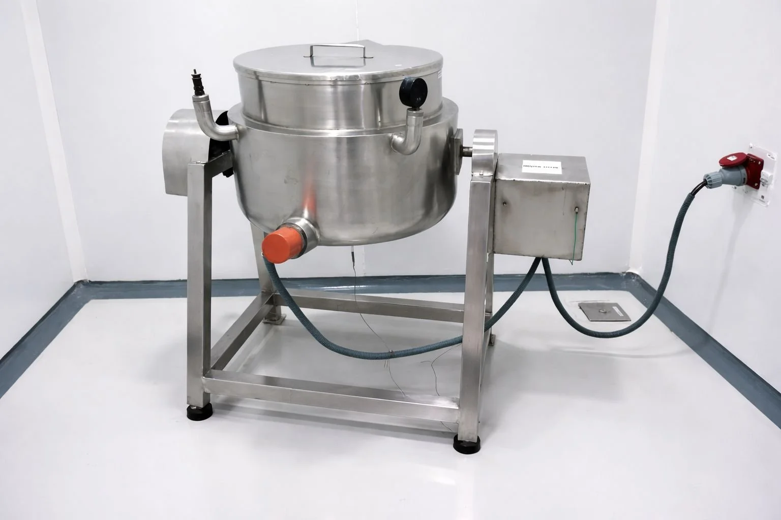 Stainless steel industrial machine connected to electrical outlet in a clean room.