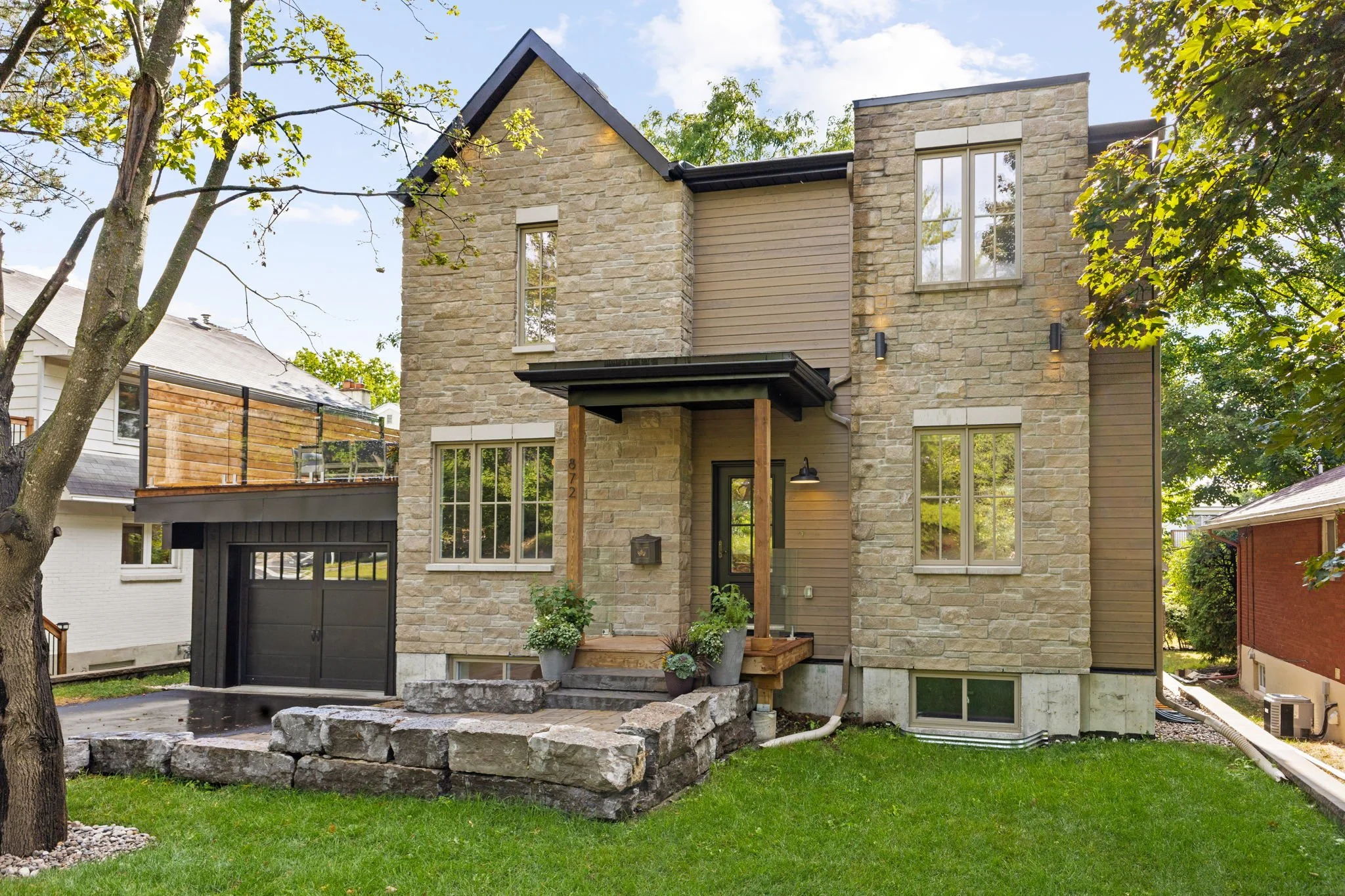 Ottawa new build custom home featuring modern infill design and a timeless stone exterior by Centennial Construction Management.