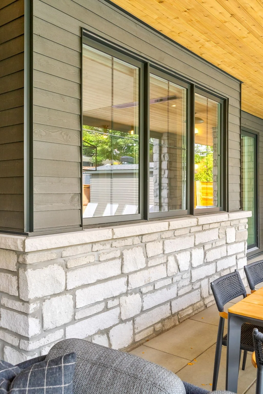 Ottawa custom home exterior with stone veneer, wood soffit, and covered patio outdoor living space