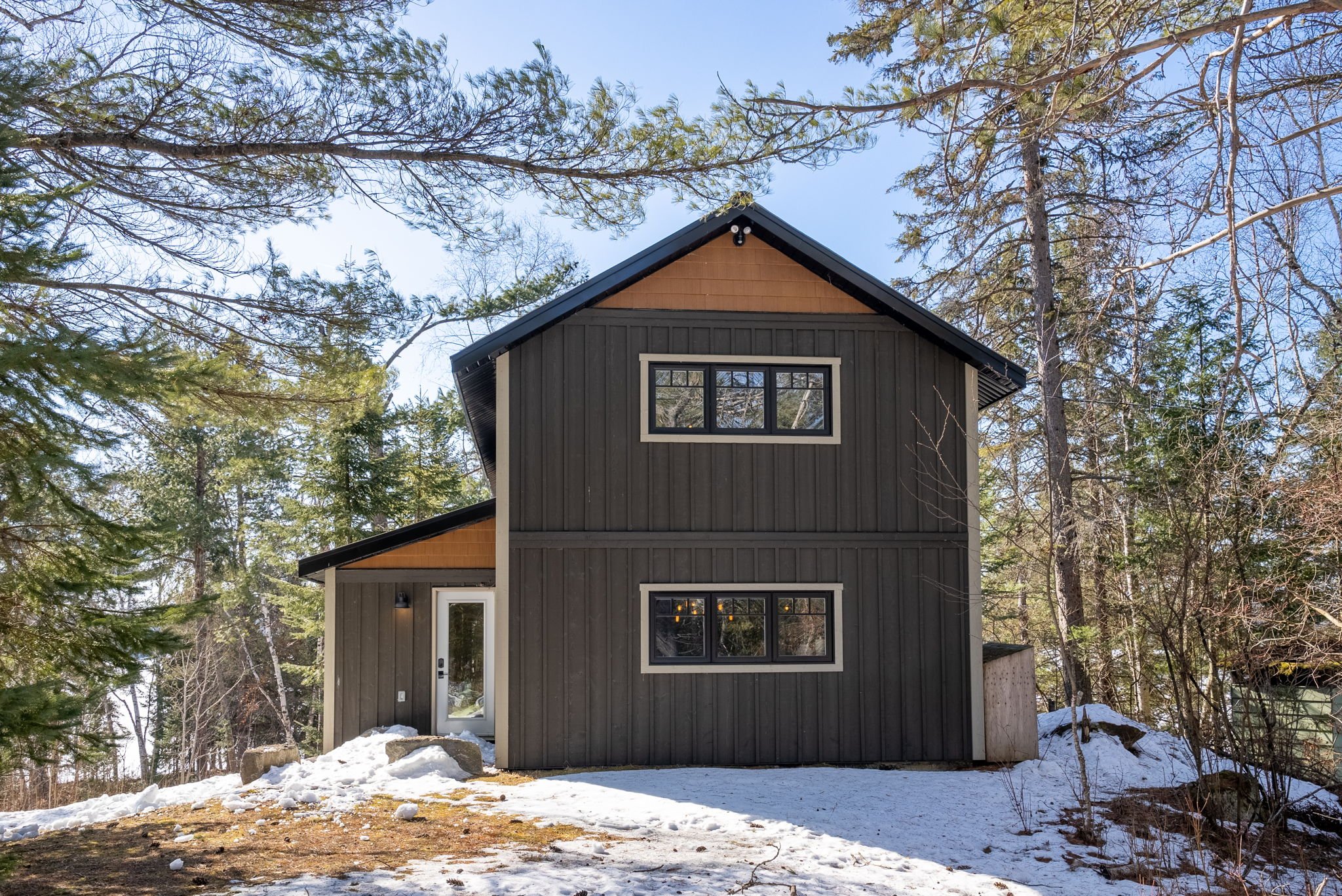 Compact cottage bunkie in Ontario designed as a secondary living space, featuring efficient layout and warm wood finishes by Centennial Construction Management.