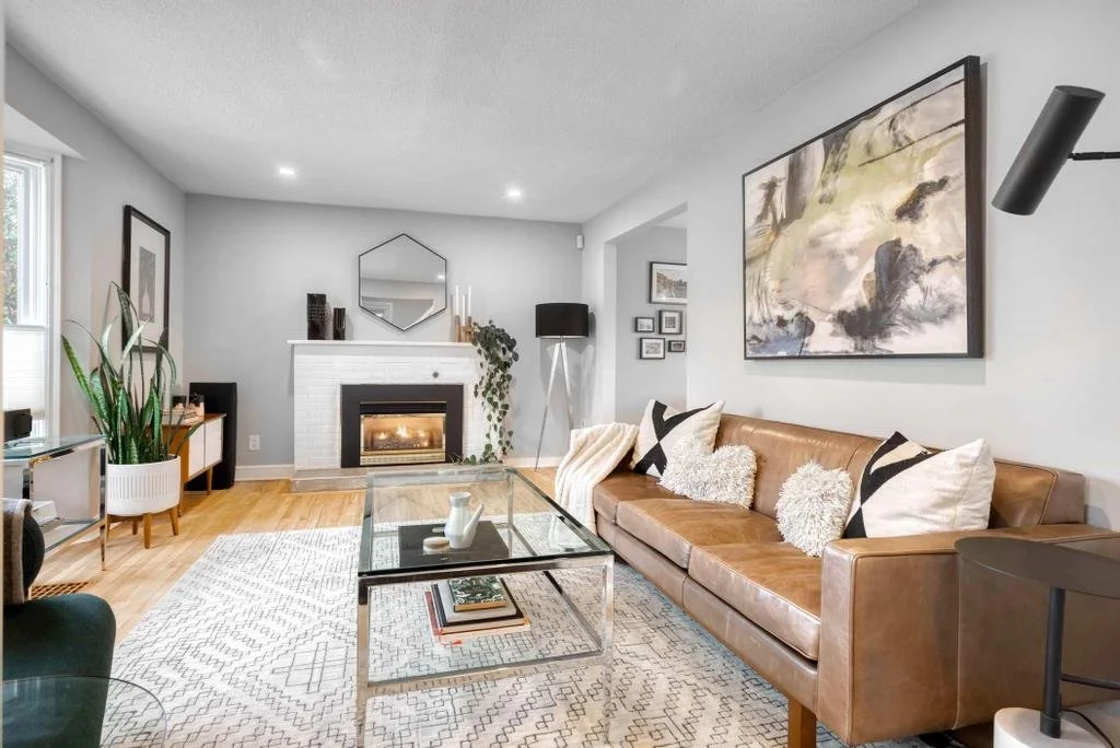 A cozy living space centered around a white brick fireplace, blending warmth, texture, and timeless design in this Ottawa home.