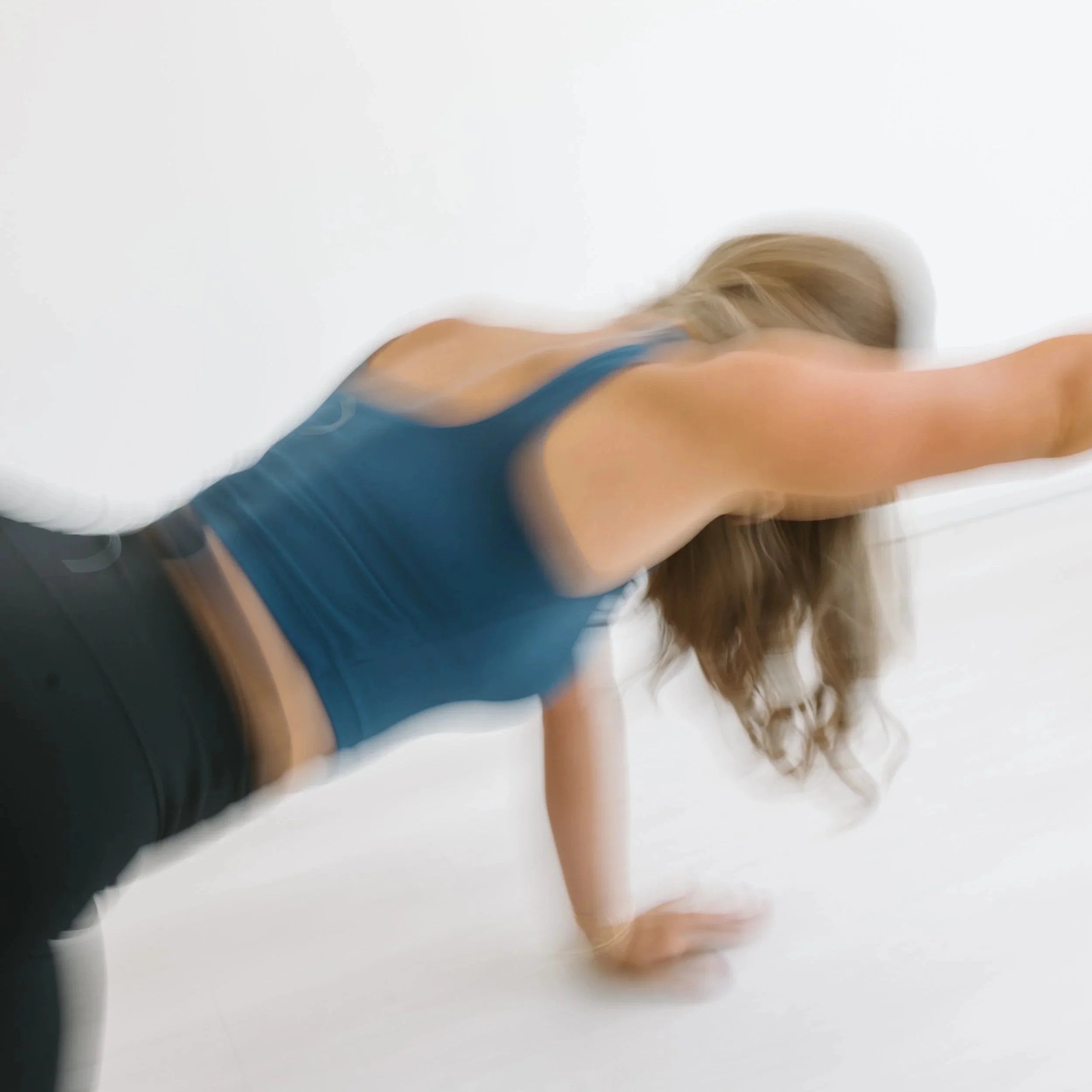 Blurred aesthetic image of a woman with blonde hair performing a pilates movement at Worth It: A Reformer Pilates Studio in Keller, Texas, near Dallas Texas, and Fort Worth, Texas.