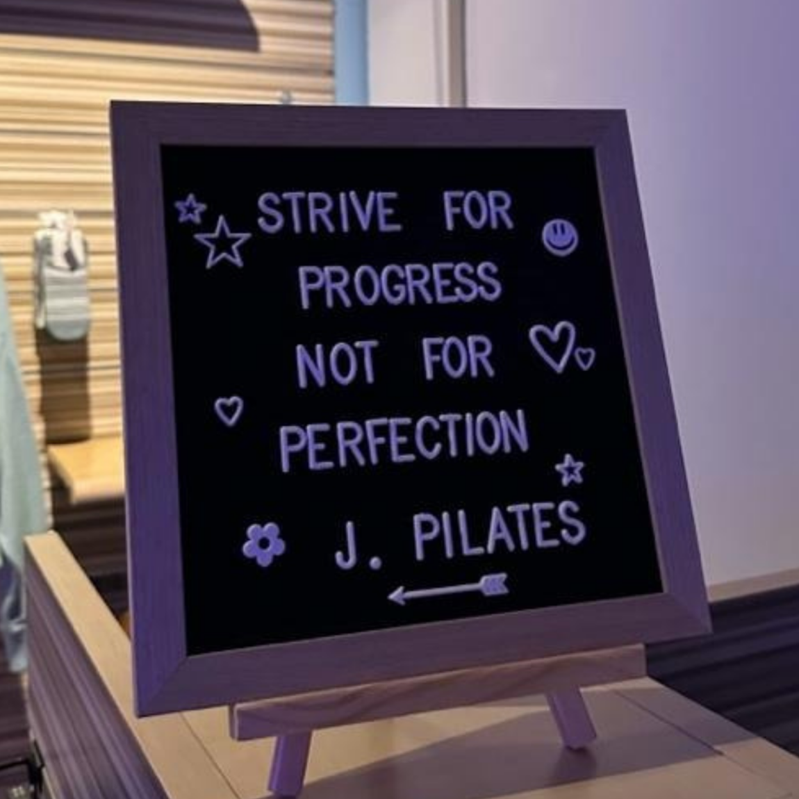A Photograph of a letter board that reads: “Strive for progress, not for perfection. - Joseph Pilates” This quote inspired Georgia May, the founder of Worth It: A Reformer Pilates Studio, to take a leap of faith and open a pilates studio.