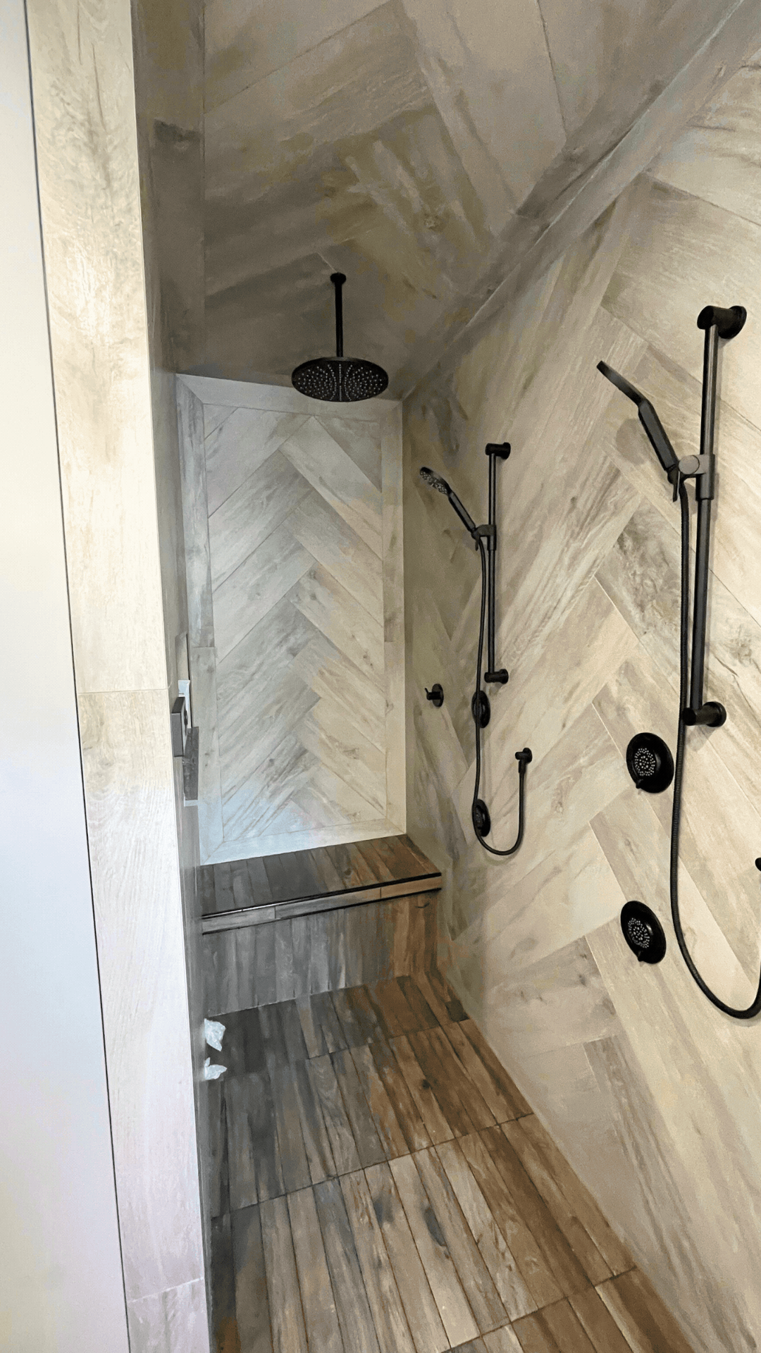 Modern shower area with tiled floor and walls.  Tile Work and Contractor Kawartha Lakes, GTA, Muskokas. Bathroom renovations with custom tile work and design.