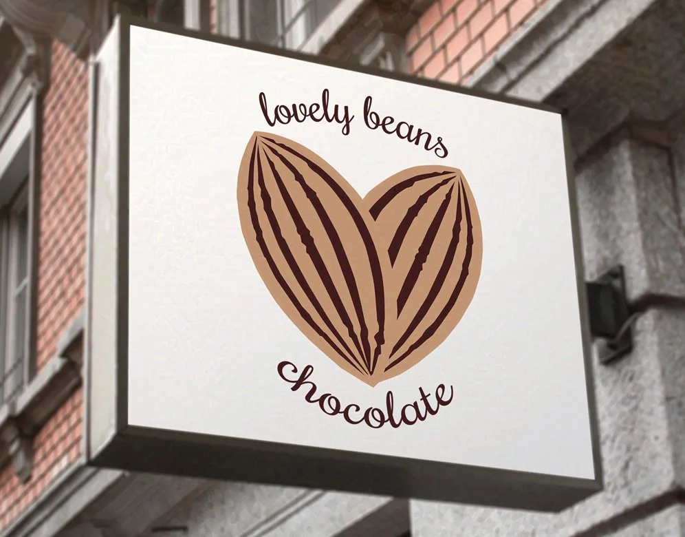 Sign for Lovely Beans Chocolate featuring a heart-shaped cocoa pod design, highlighting artisanal chocolate offerings.