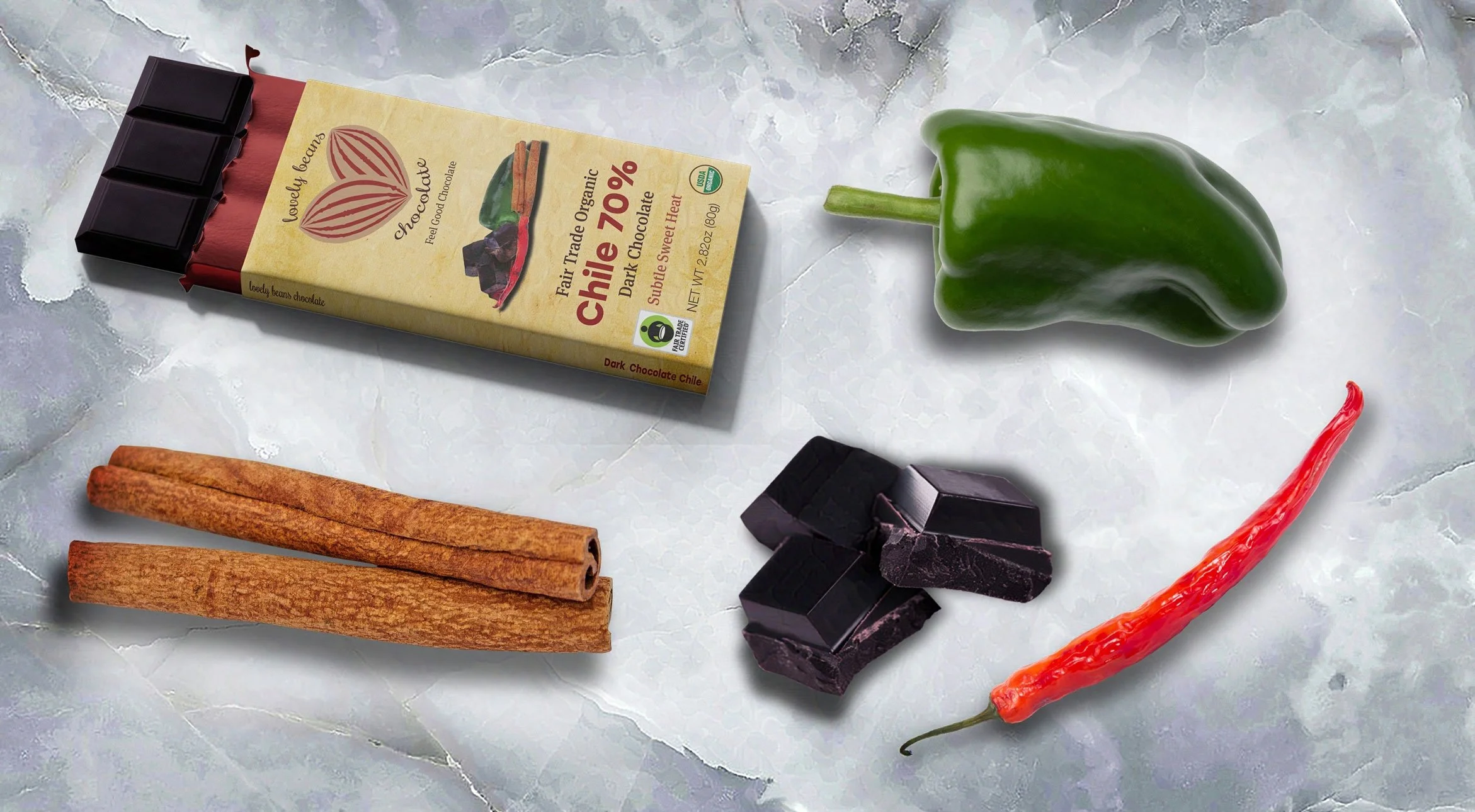 Chocolate bar labeled "Chile 70%" with cinnamon sticks, powdered cinnamon, dark chocolate pieces, a green chile pepper, and a red chile pepper on a gray-textured surface.