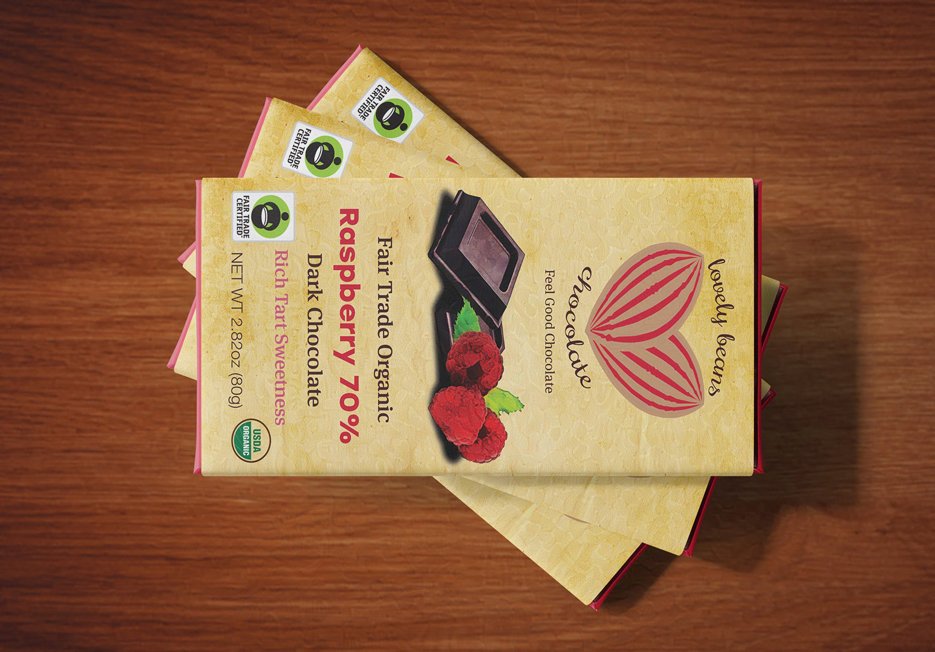 Three stacked bars of Fair Trade Organic Raspberry 70% Dark Chocolate on a wooden surface.