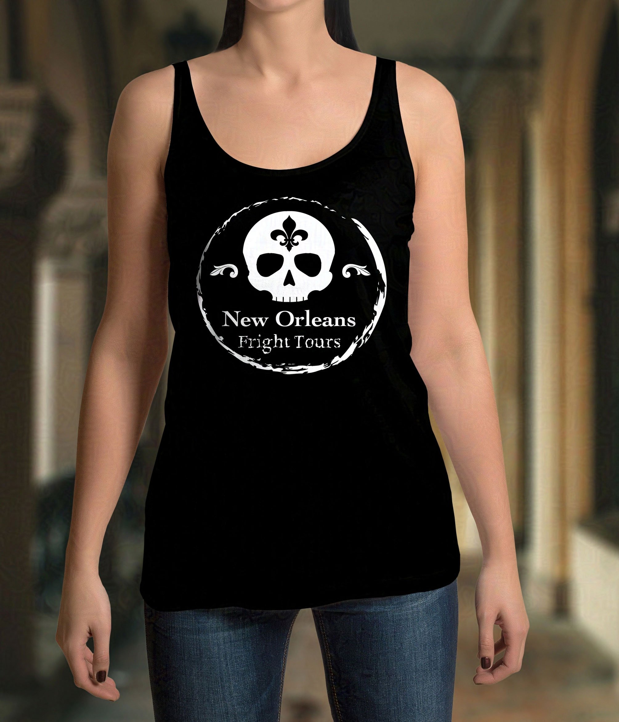 White woman modeling a black tank top featuring a white skull, fleur-de-lis, and “New Orleans Fright Tours” graphic, creating an eerie tone.