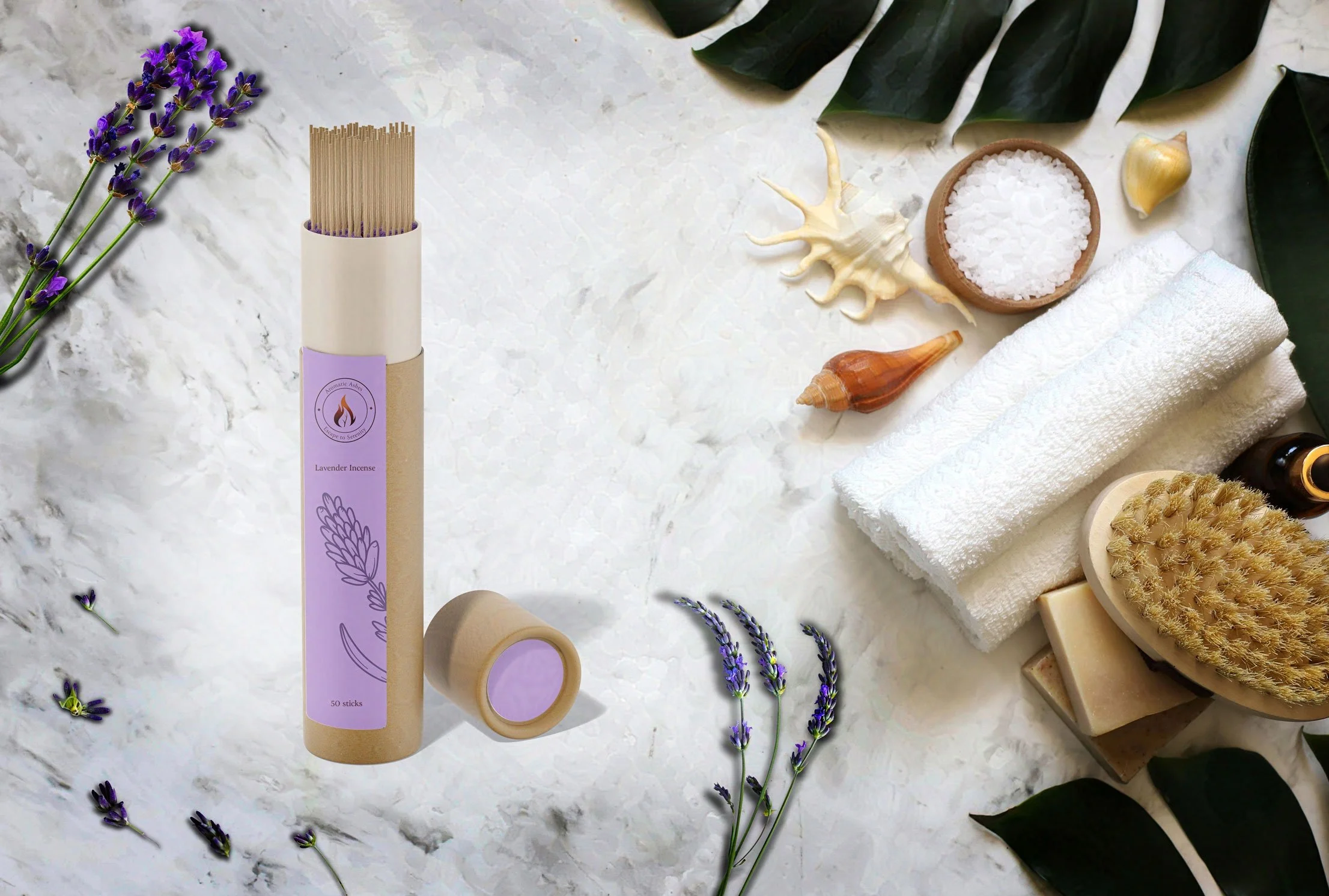 Lavender incense sticks in a tube beside fresh lavender, bath towel, brush, seashells, salt, and soap on a marble surface.