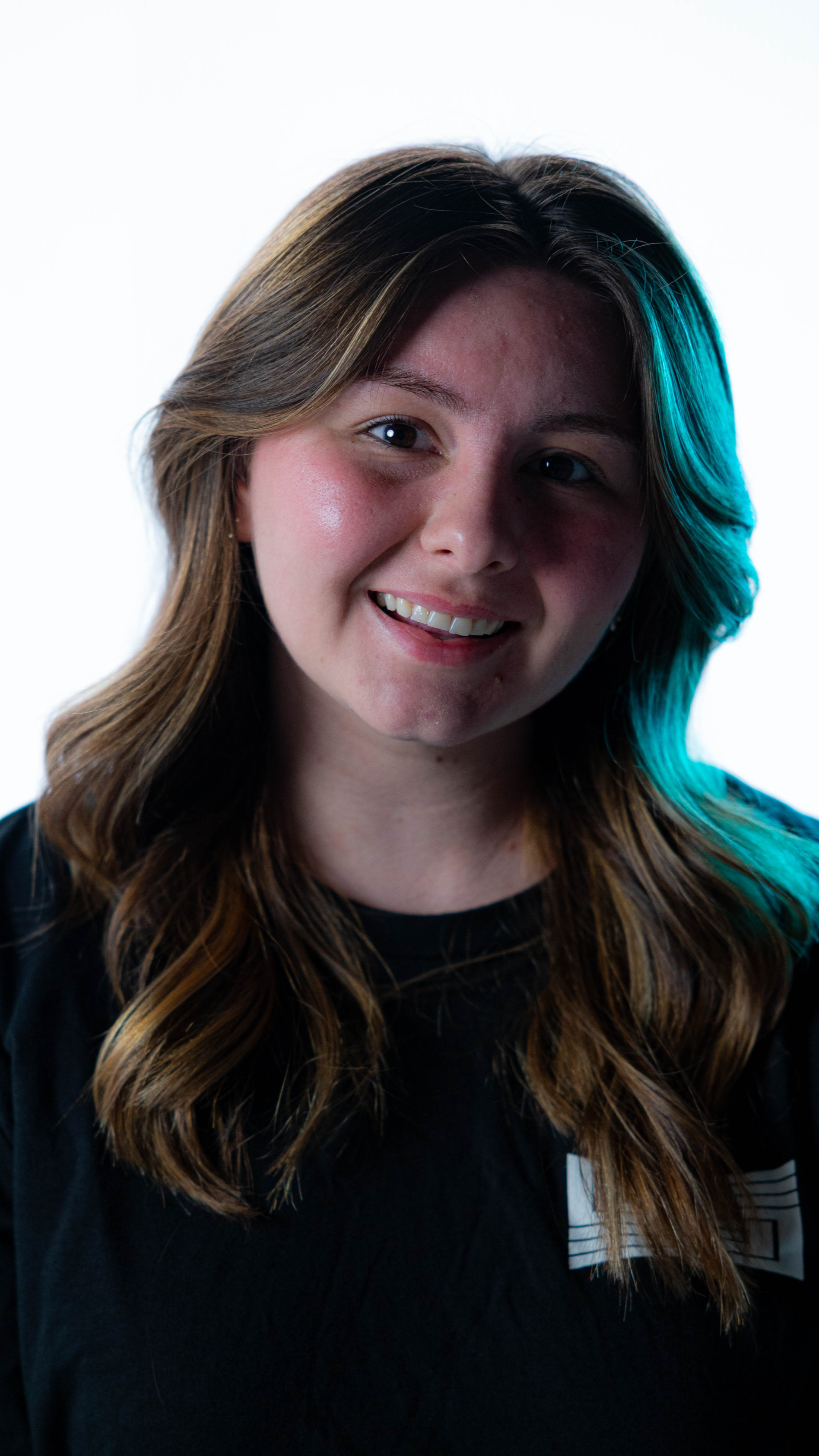 Producer's Assistant, Madeleine Moore, wearing a SHOTCALLER shirt against a white background with lighting effects.