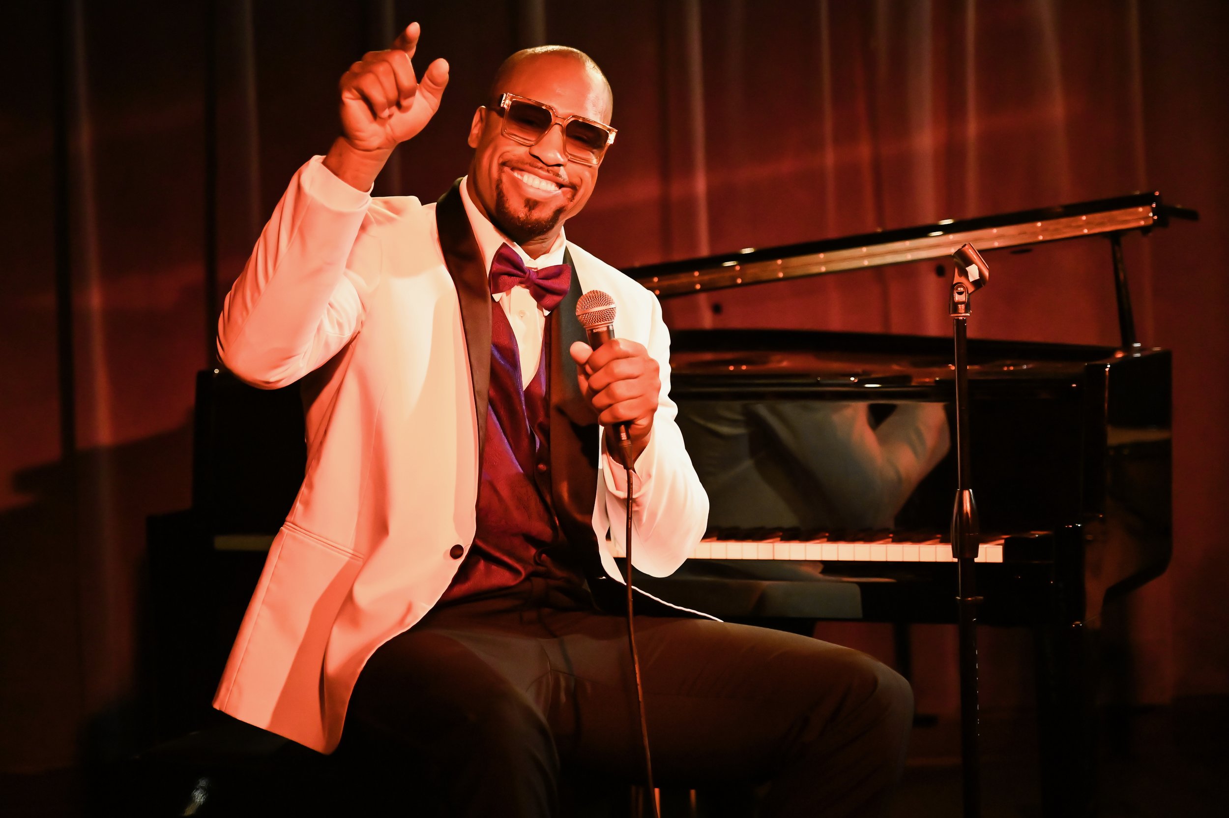 A behind-the-scenes photo of actor Vernon Davis sitting at a piano for the movie Tonic.  