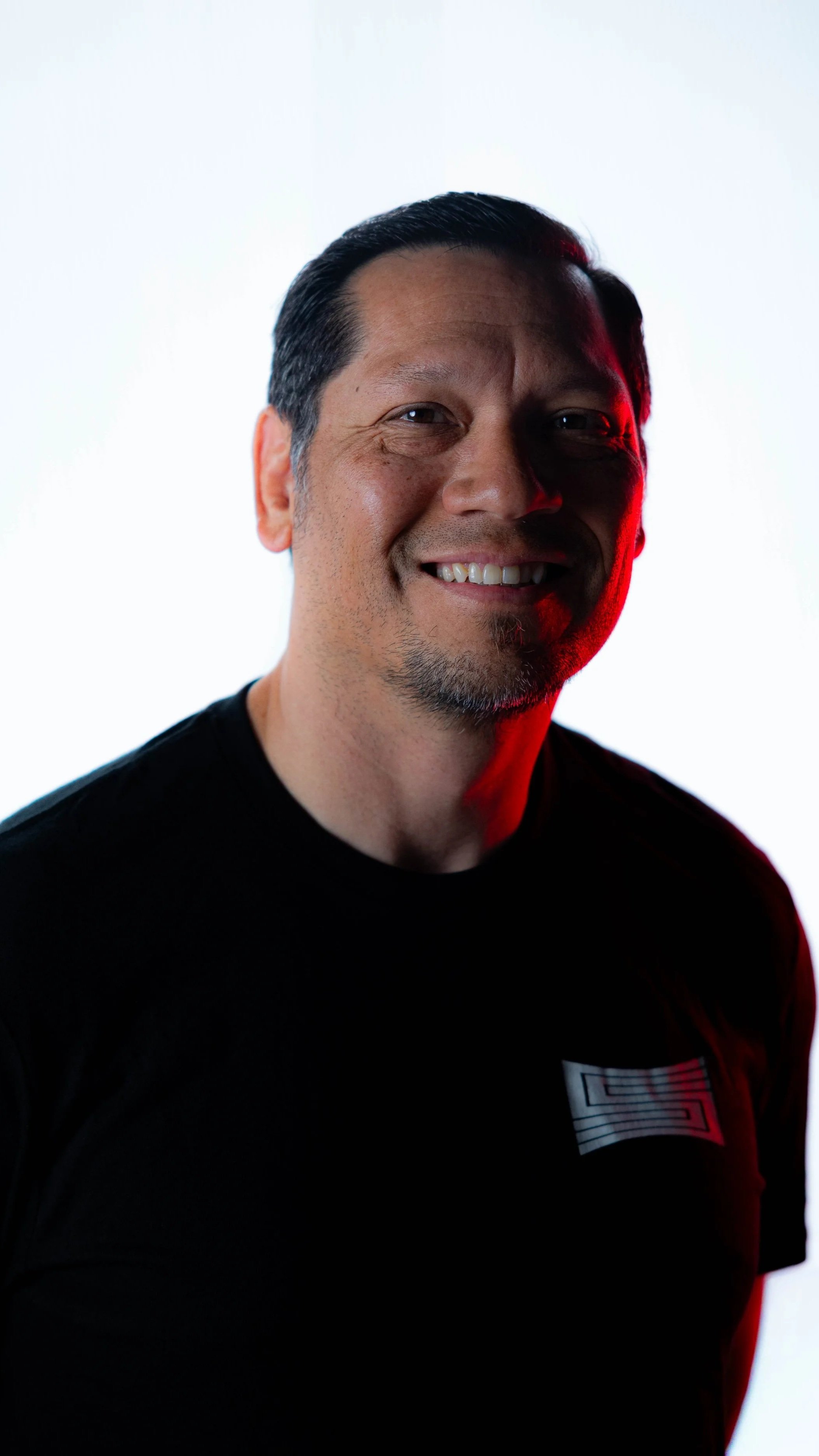 Producer and CEO, Jason Starne, wearing a SHOTCALLER shirt against a white background with lighting effects.