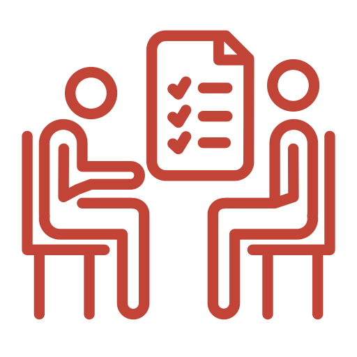 Two people sitting at a table with a document containing checkmarks between them, symbolizing a meeting or interview.