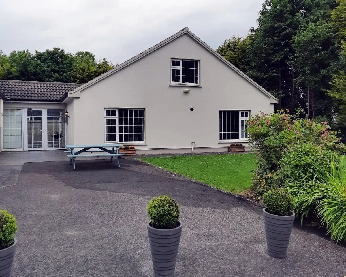 Odies Lodge exterior with courtyard, picnic bench and garden planting, single-level self-catering accommodation at Kilbeg Pier, Lough Corrib, County Galway