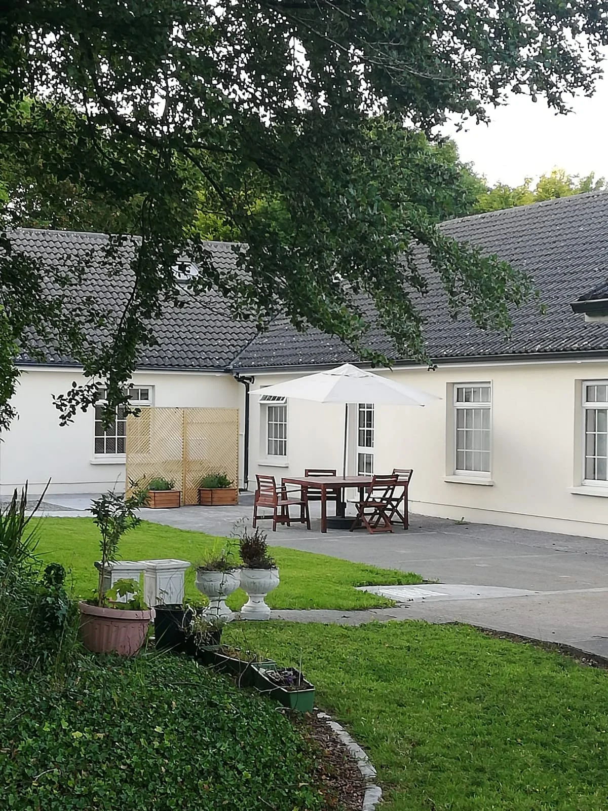 Fishermans Lodge exterior with outdoor dining set and garden, self-catering accommodation at Kilbeg Pier, Lough Corrib, County Galway