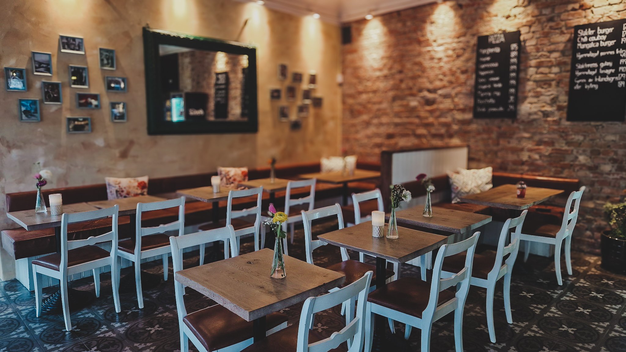 Interiør av en restauranten Rolis Bodega. Veggene er av murstein og pyntet med fotografier og menyer. - Rolis Bodega, Nordstrand, Oslo