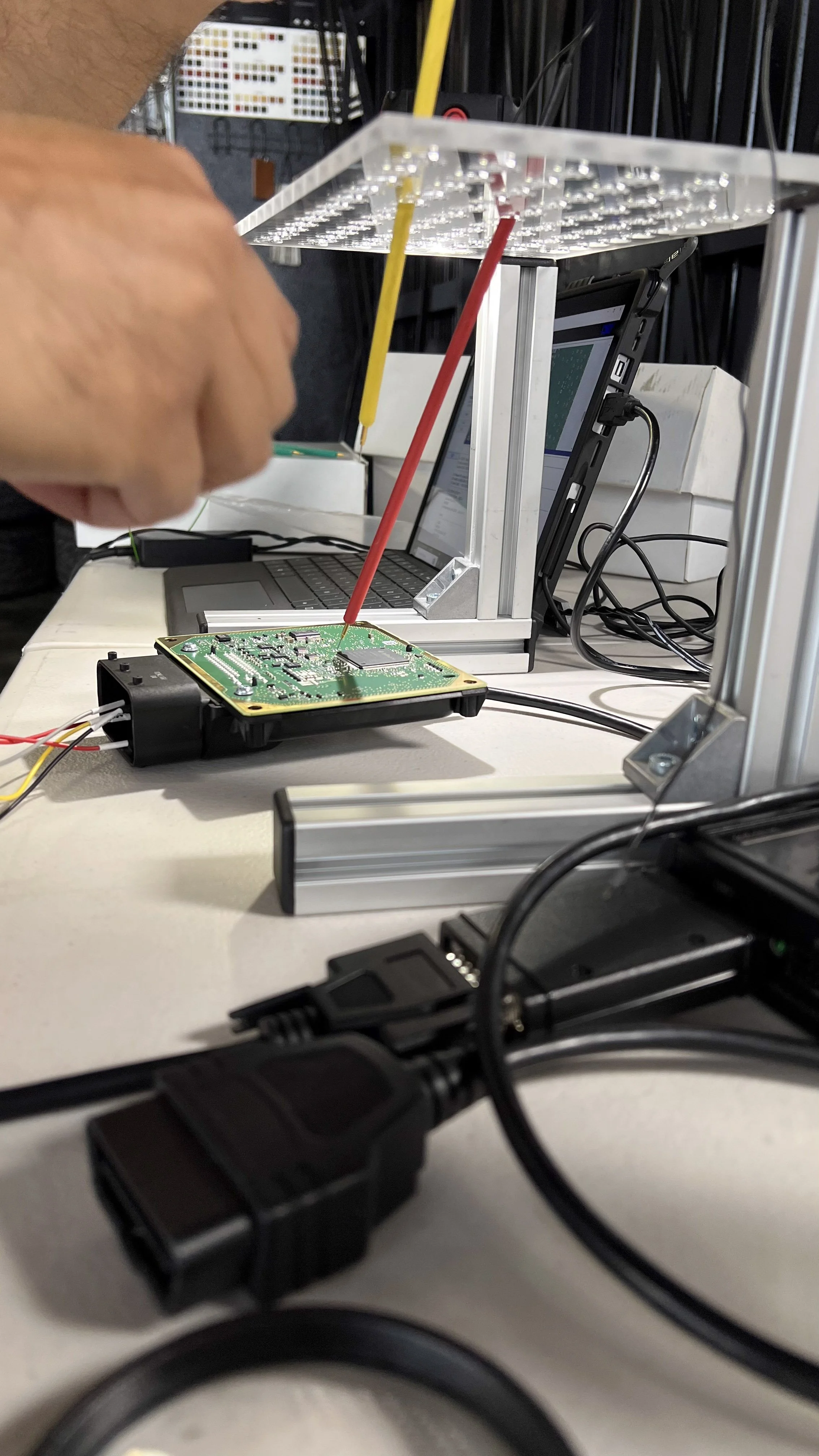 Person working with a Porsche PDK ECU module and preparing to calibrate the device in a lab or workshop. 