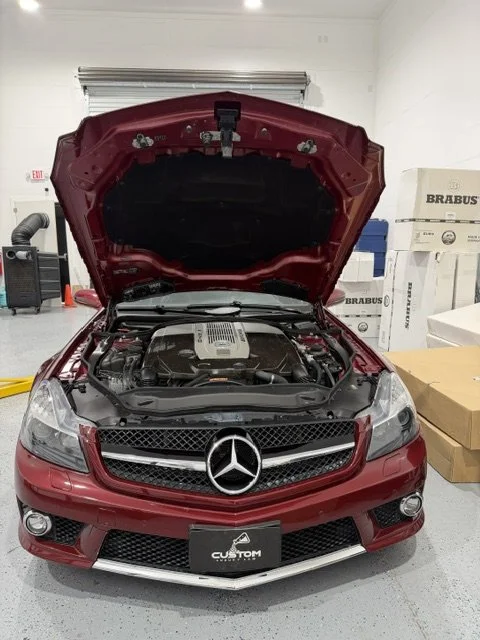 Red Mercedes-AMG SL 65 with the hood raised for service at Custom Luxury Lab in Frisco, TX