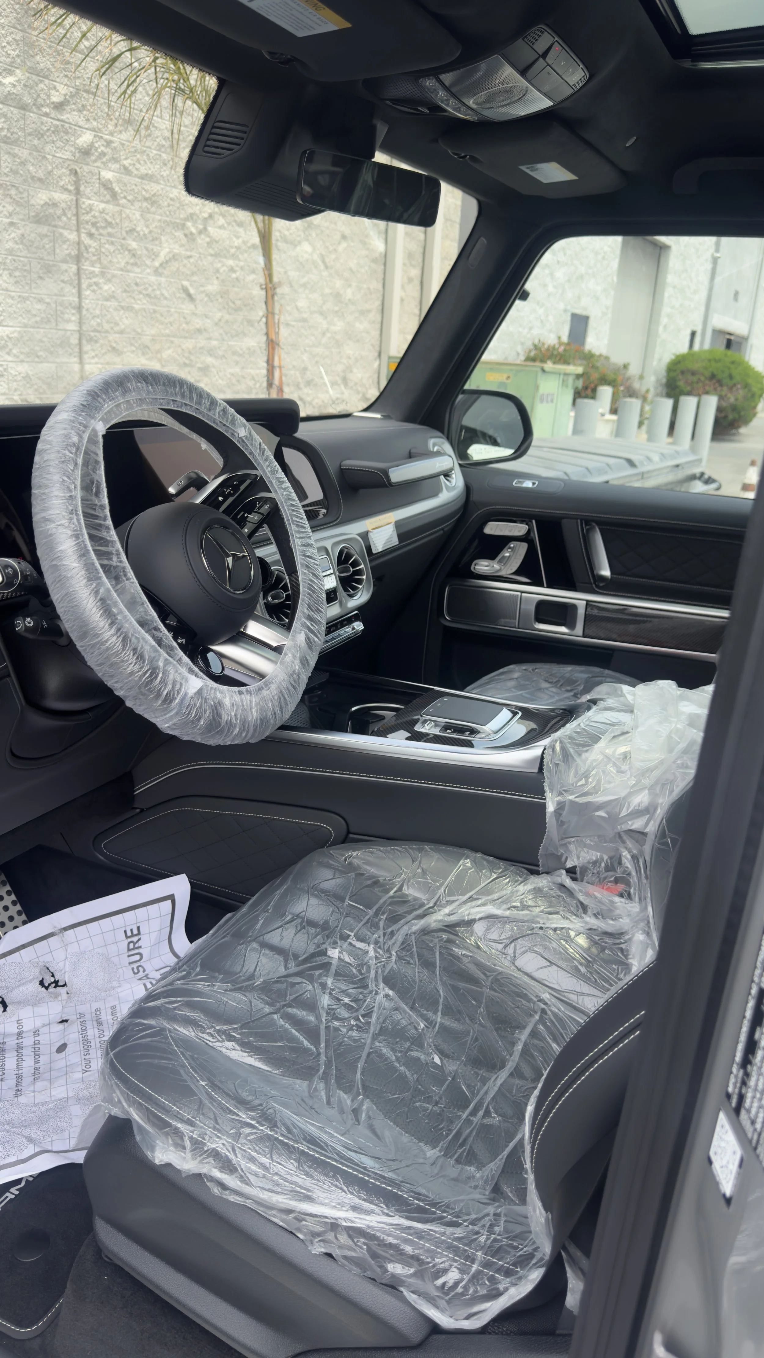 Mercedes-Benz G-Class interior with the seats and steering wheel still in protective covers at Custom Luxury Lab in Frisco, TX