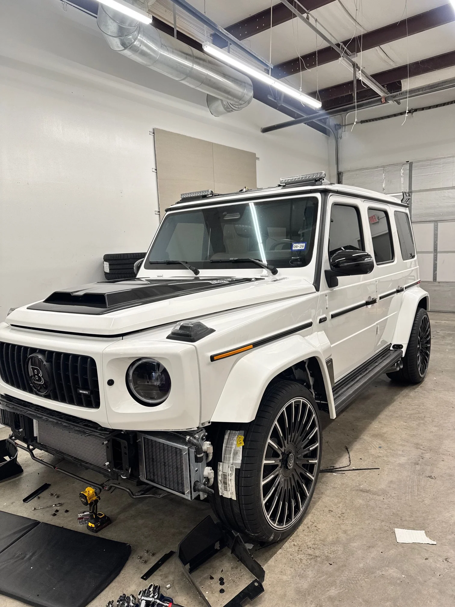 A white Mercedes-Benz G63 Brabus 26 kit build. Front end is being prepped for front widebody bumper install. 