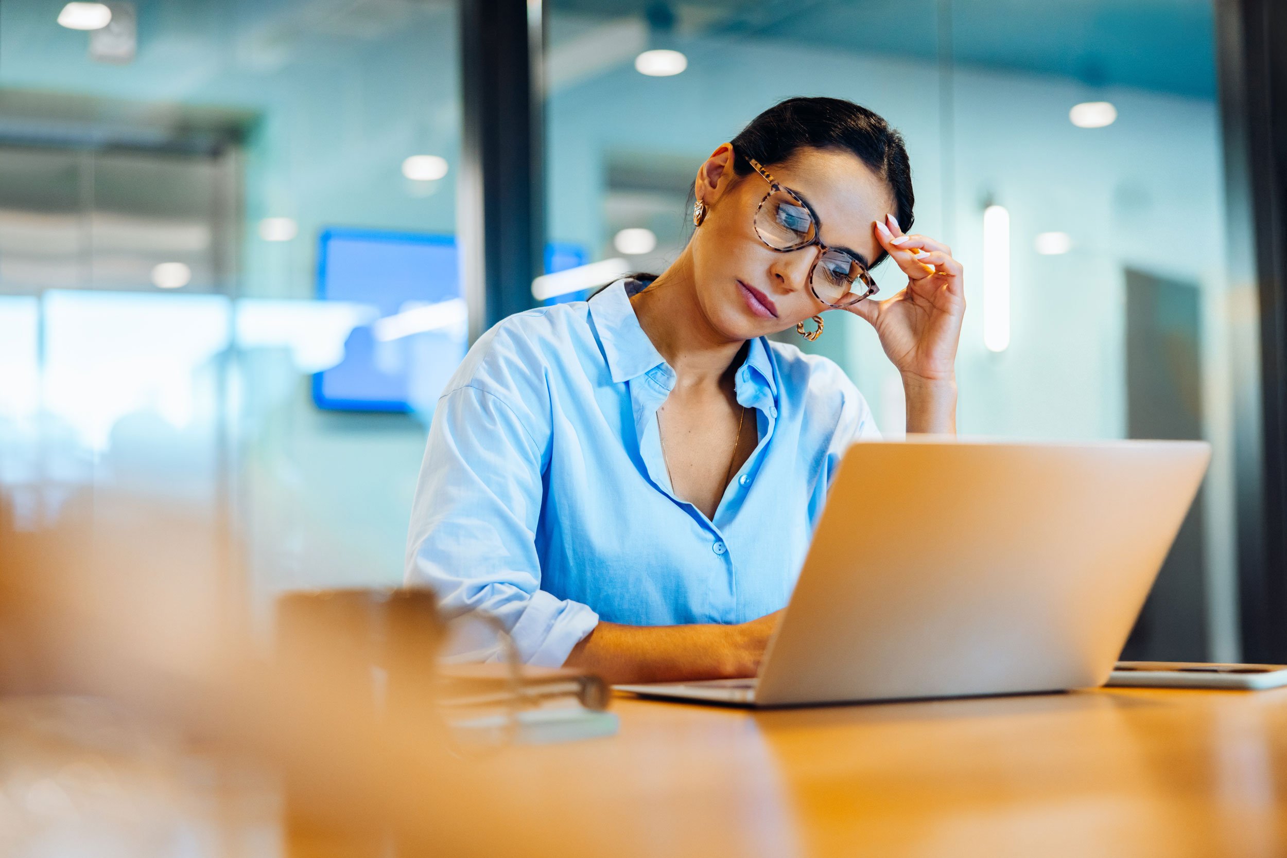 Frustrated professional overwhelmed at her laptop, unsure how to move forward in her career.
