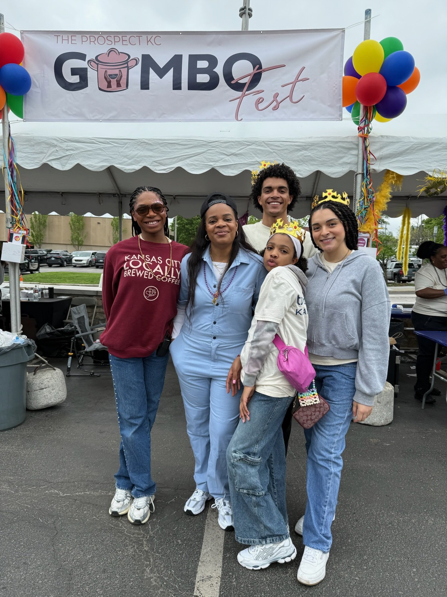 Five people standing together at GMOV Fest event under a tent, with balloons and a banner that reads 'The Prospect KC GMov Fest'.