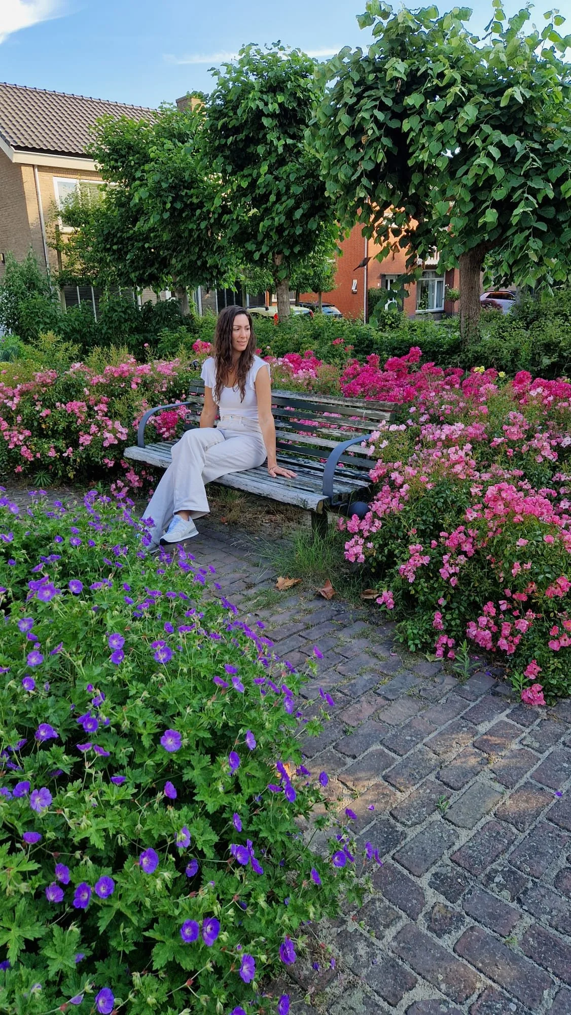 Marjolein, oprichter van Female Impact Leader in een kleurrijke omgeving met veel bloemen.