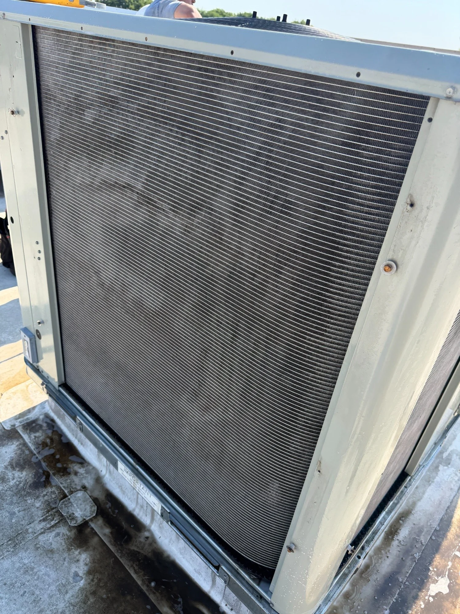 An exposed outdoor condenser coil photographed during an HVAC service visit.
