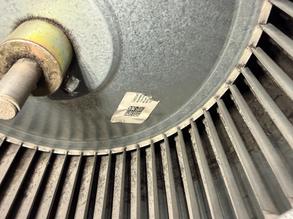 Close-up of visible dust buildup along the blades of an HVAC blower wheel.