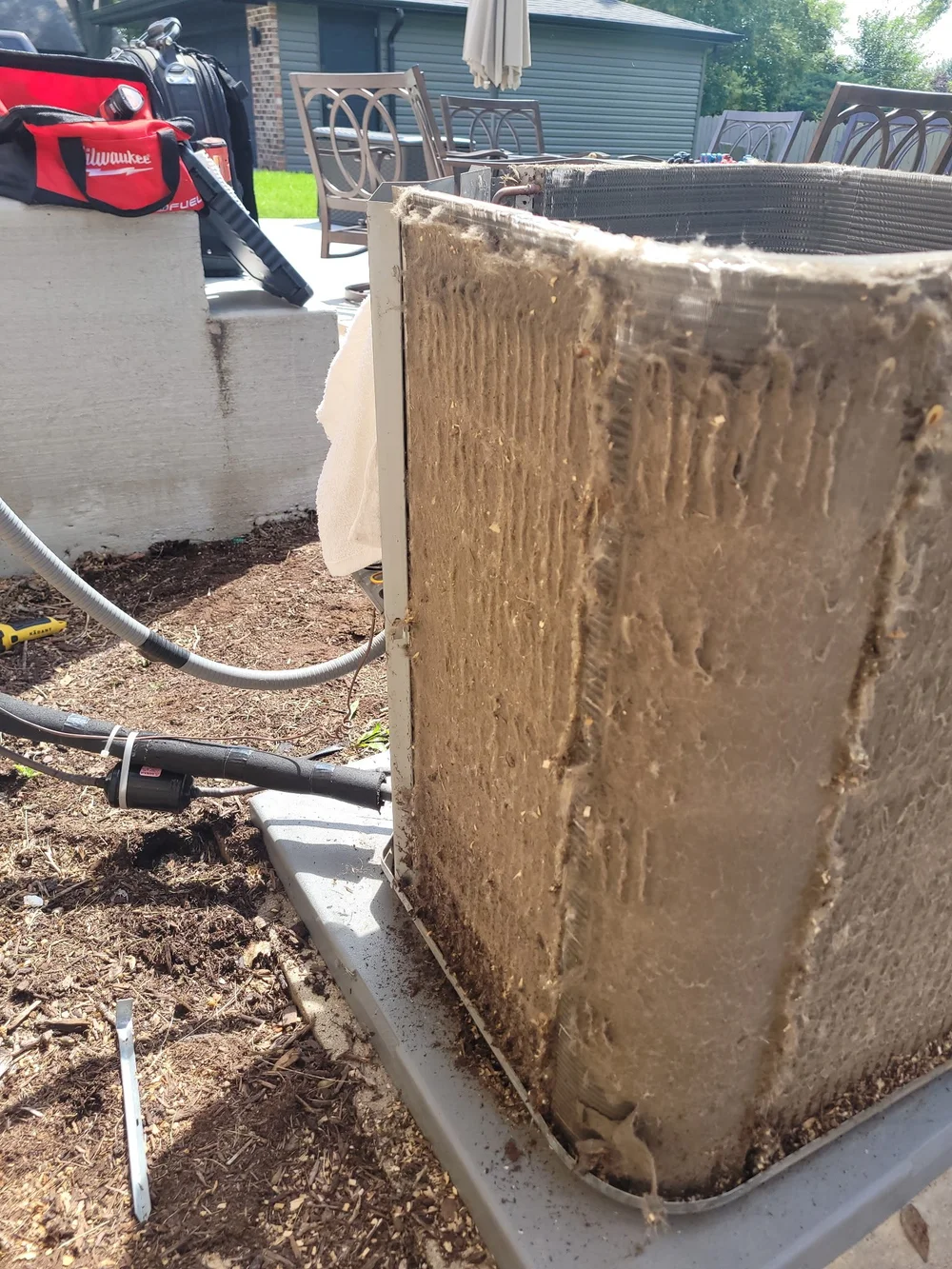 Accumulated debris on the exterior of an exposed outdoor condenser coil.