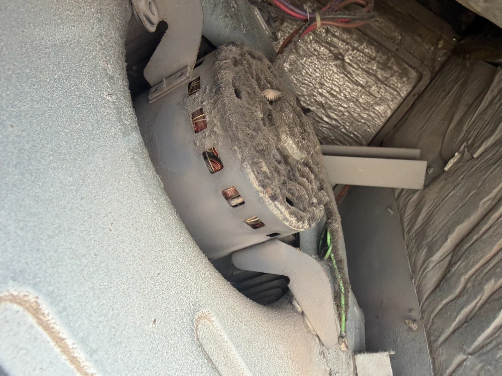Dust buildup on a blower motor inside an HVAC cabinet.
