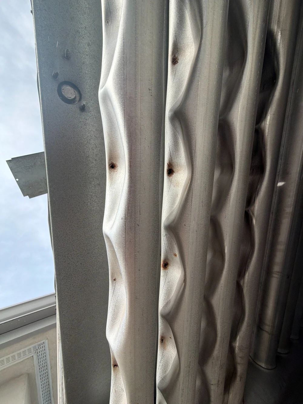 Close-up of a metal furnace heat exchanger surface during inspection.
